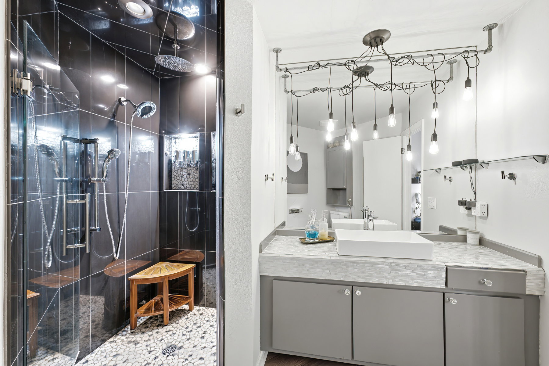 Bathroom featuring a walk-in shower with dark tile surround, pebble flooring, and built-in bench