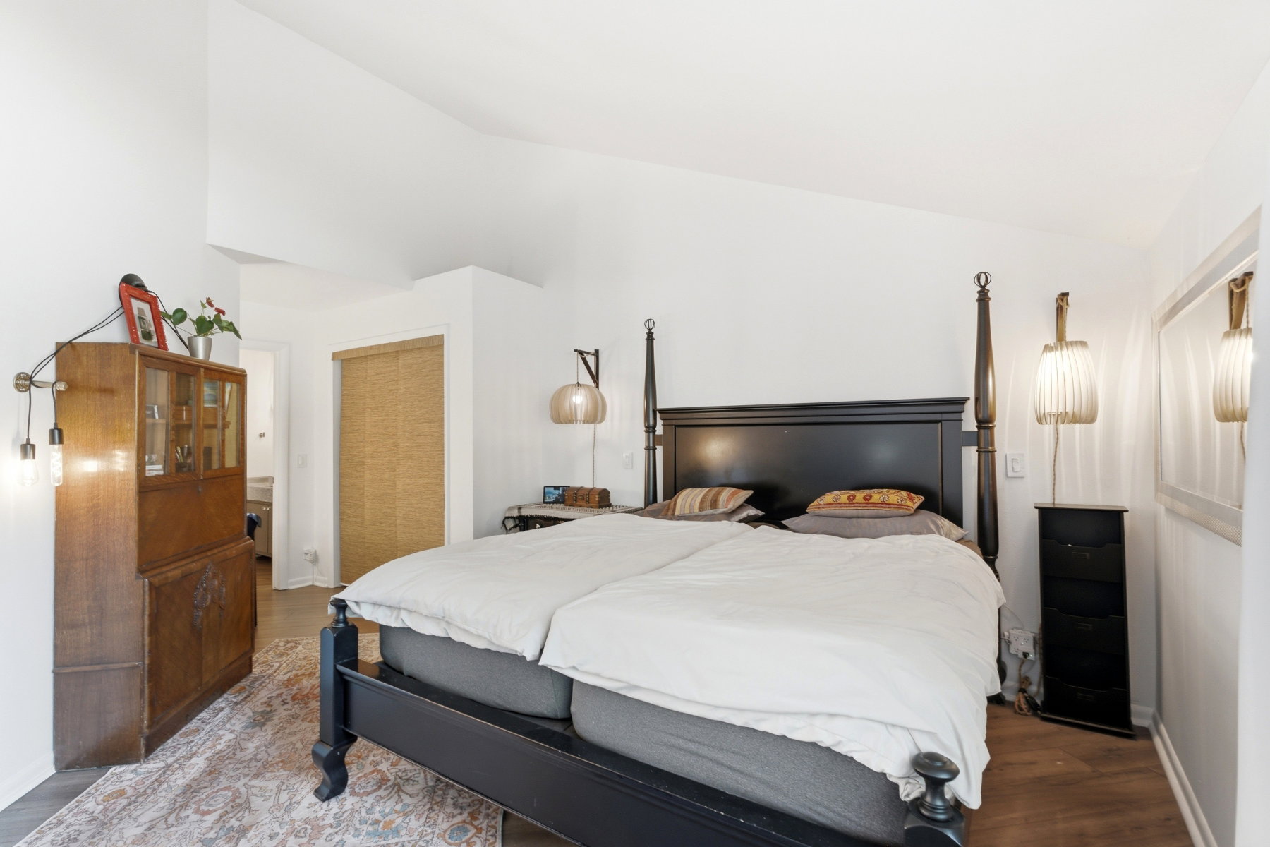Spacious bedroom featuring vaulted ceilings and wood-finish flooring