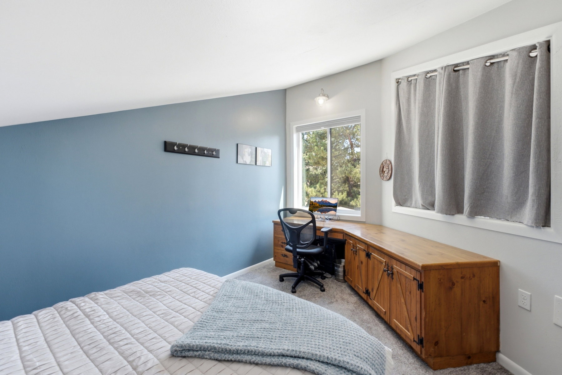 Integrated wood-finish desk and cabinetry featuring barn door style accents