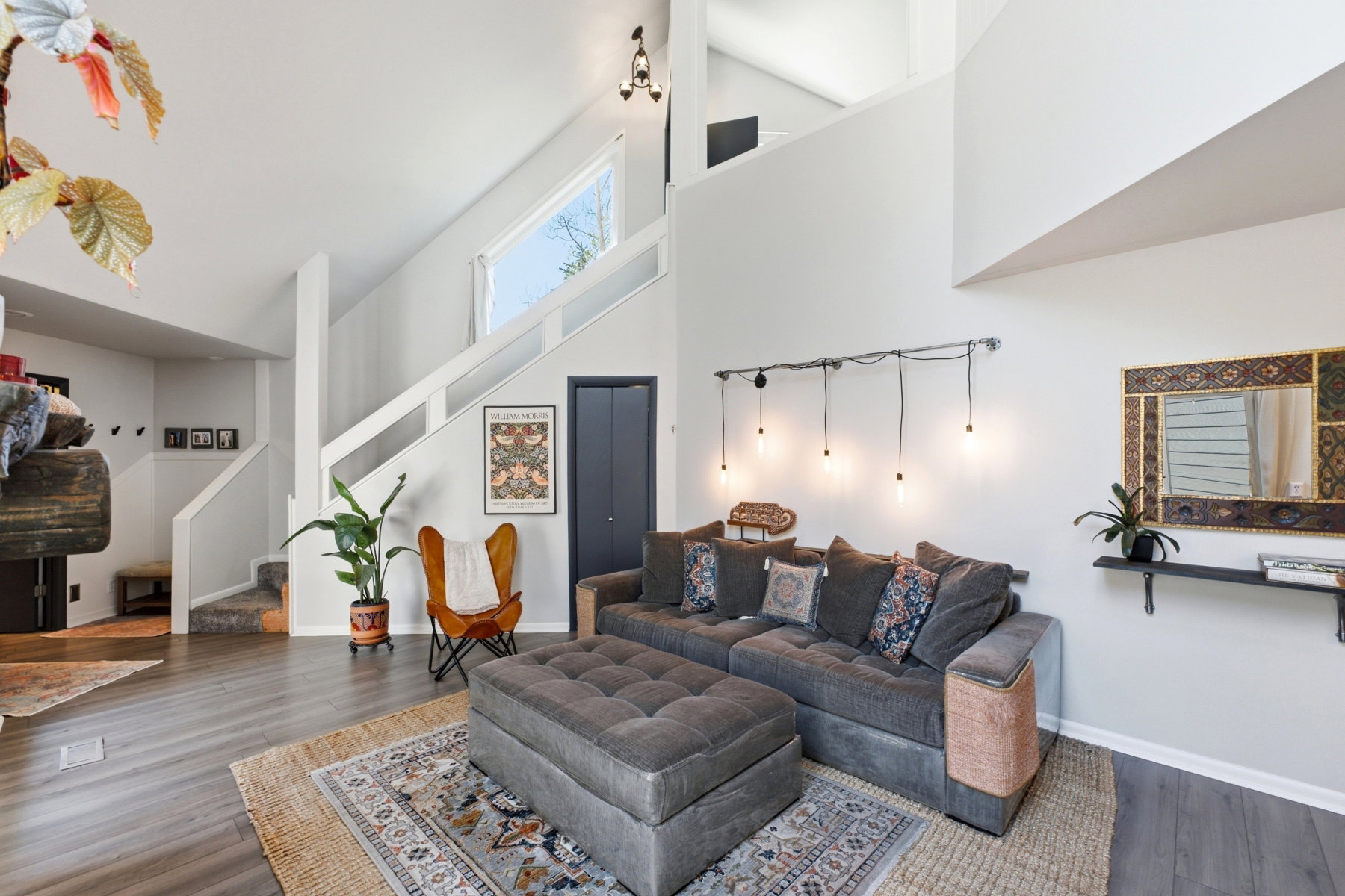 Vaulted ceilings with an upper window, wood-finish flooring, and a built-in staircase