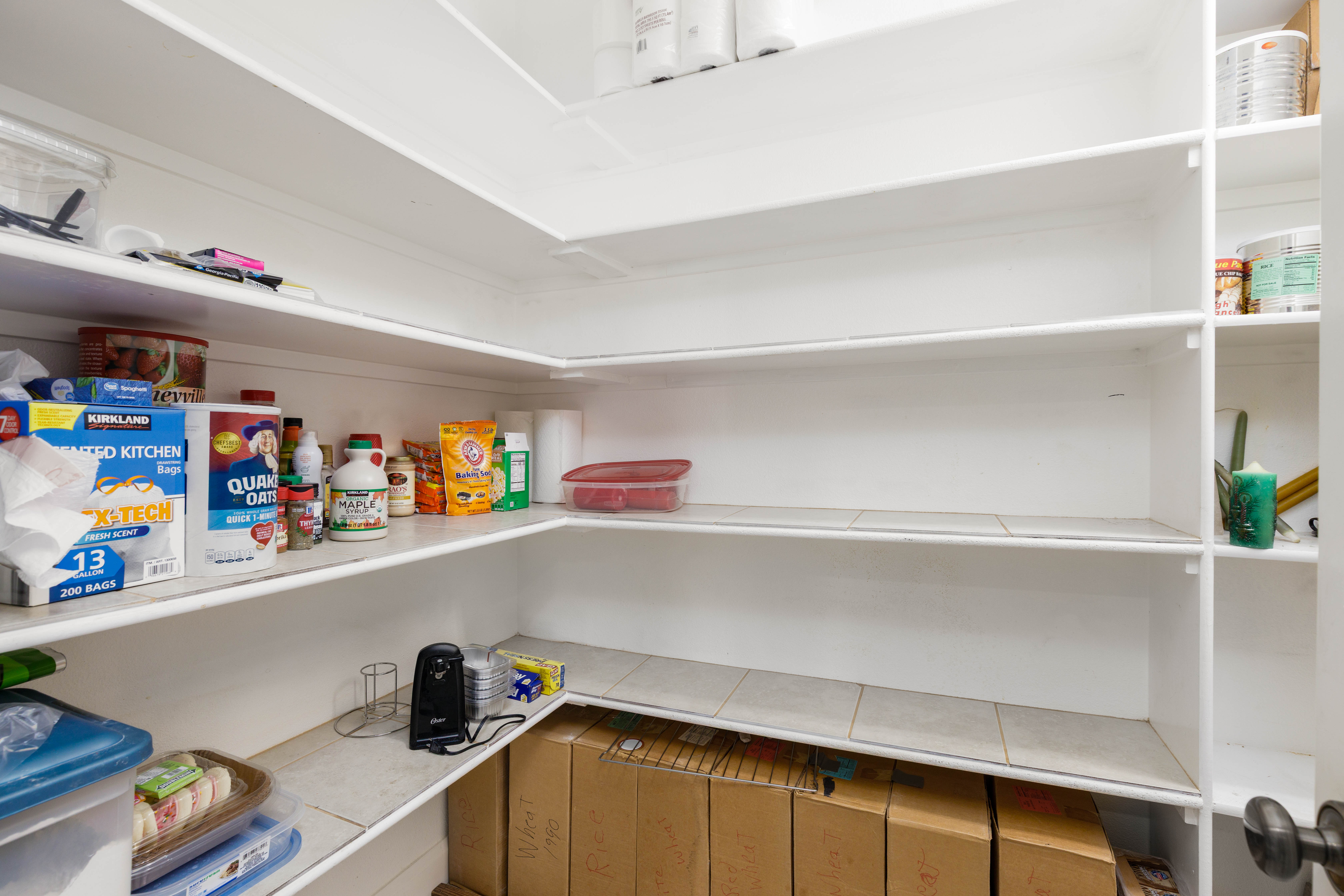 Spacious pantry featuring multiple tiers of white shelving