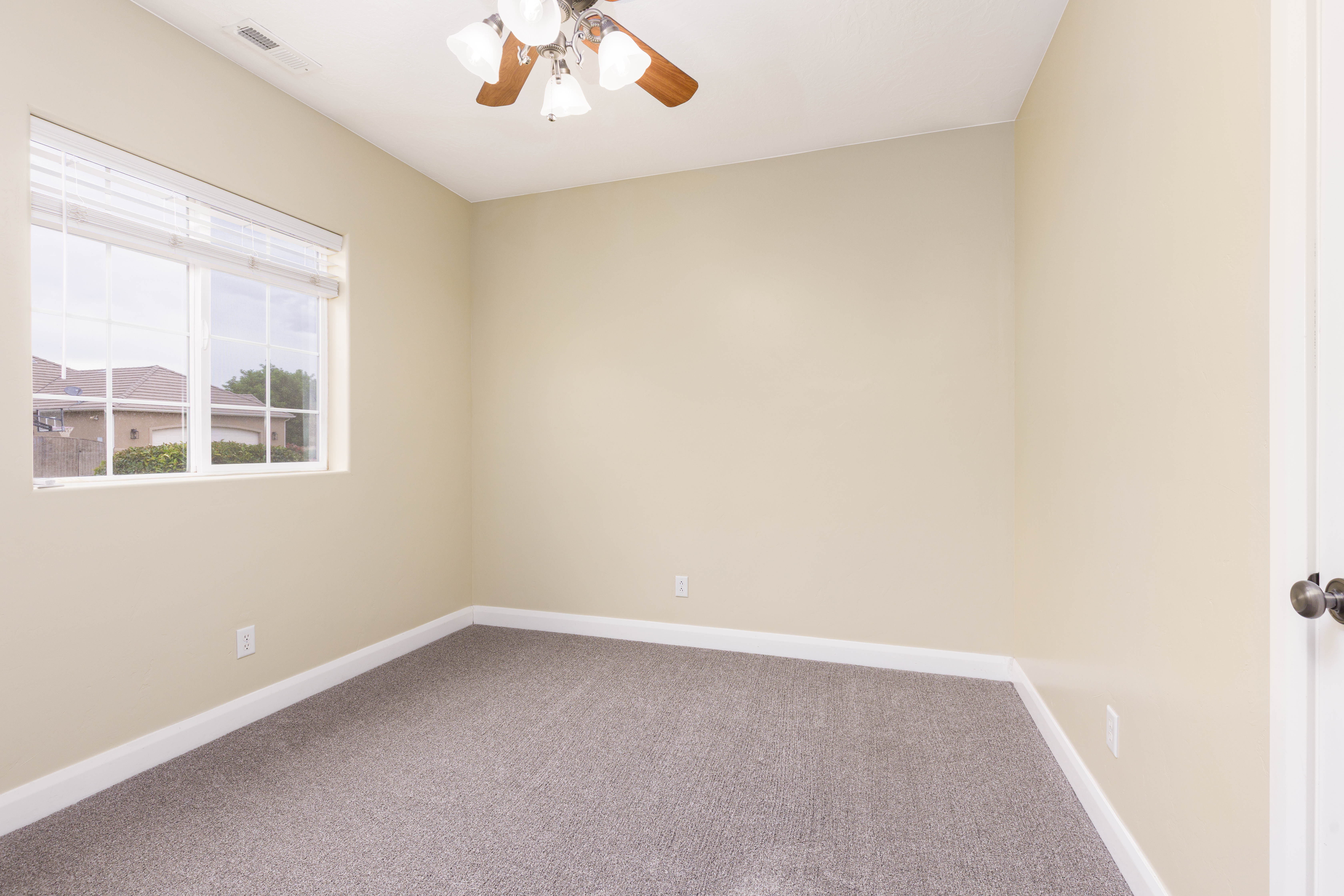Light-toned interior space with gray carpeting and white baseboards