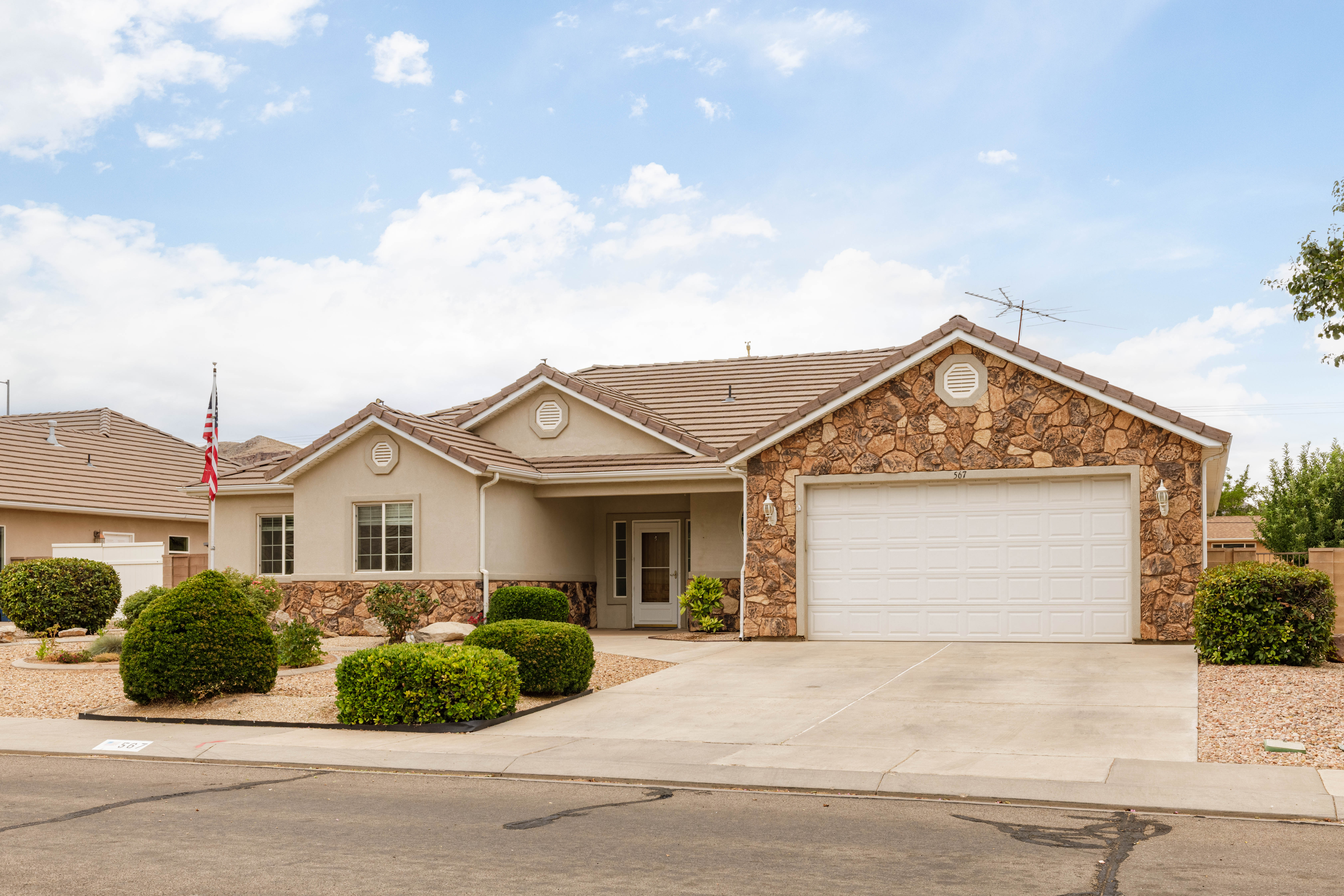 Single-story residence featuring a tile roof, stucco exterior, and natural stone accents