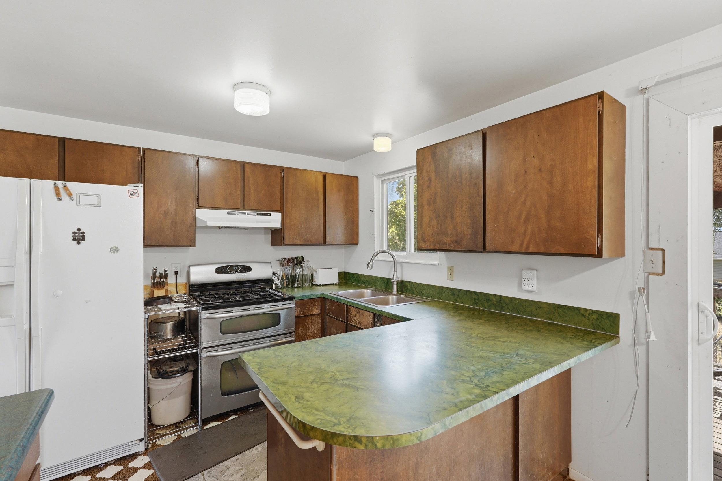 Kitchen featuring wood cabinetry, green countertops, and a white refrigerator