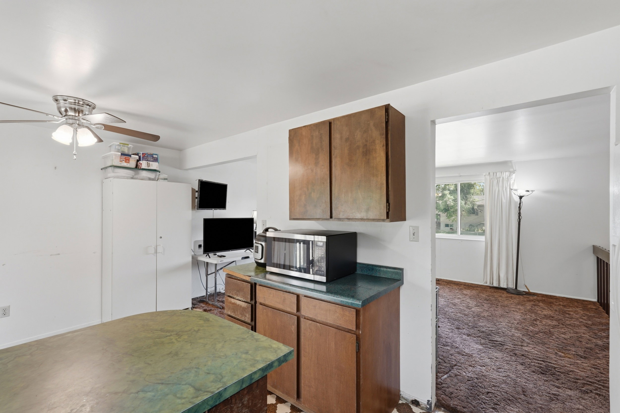 Kitchen featuring wood-finish cabinetry, green-toned countertops, and a built-in microwave