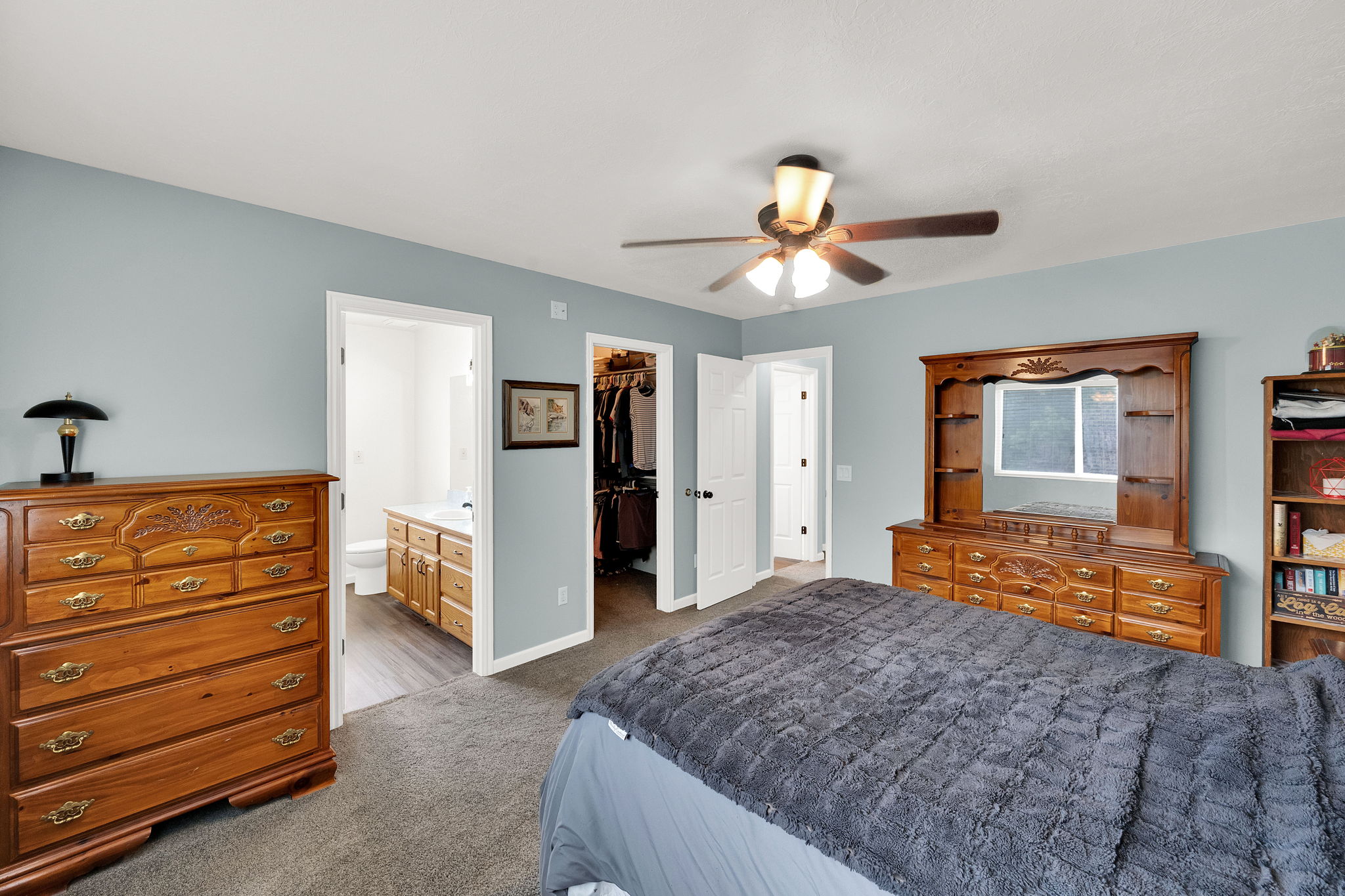 Bedroom featuring light blue walls, gray carpet, and a ceiling fan with integrated lighting