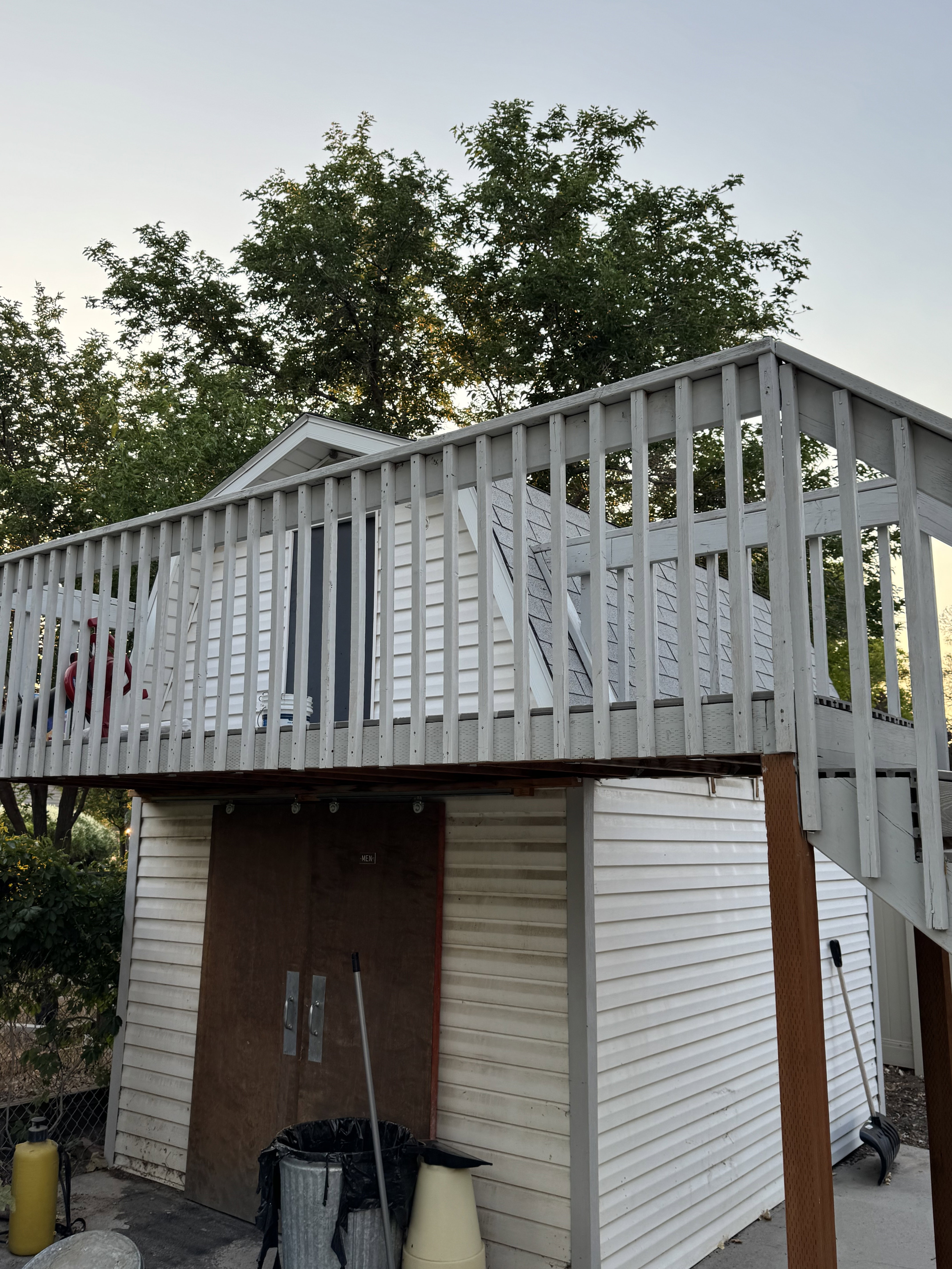 Shed is 10 ft by 12 ft. Elevated deck with wood railing on the shed.