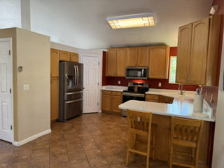 Kitchen featuring wood cabinetry, stainless steel appliances, and a breakfast bar