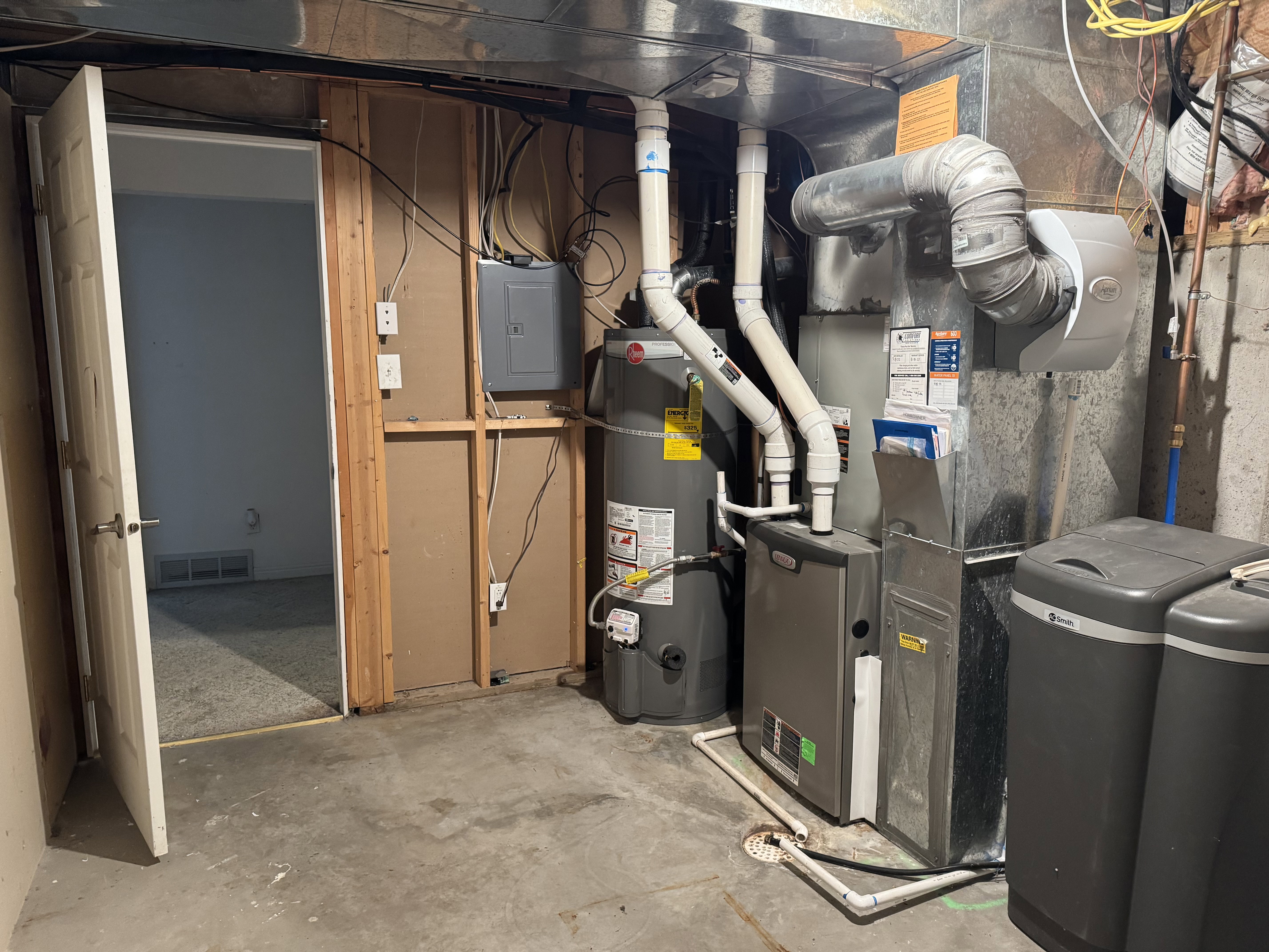 Utility area featuring a furnace, water heater, and water softener system