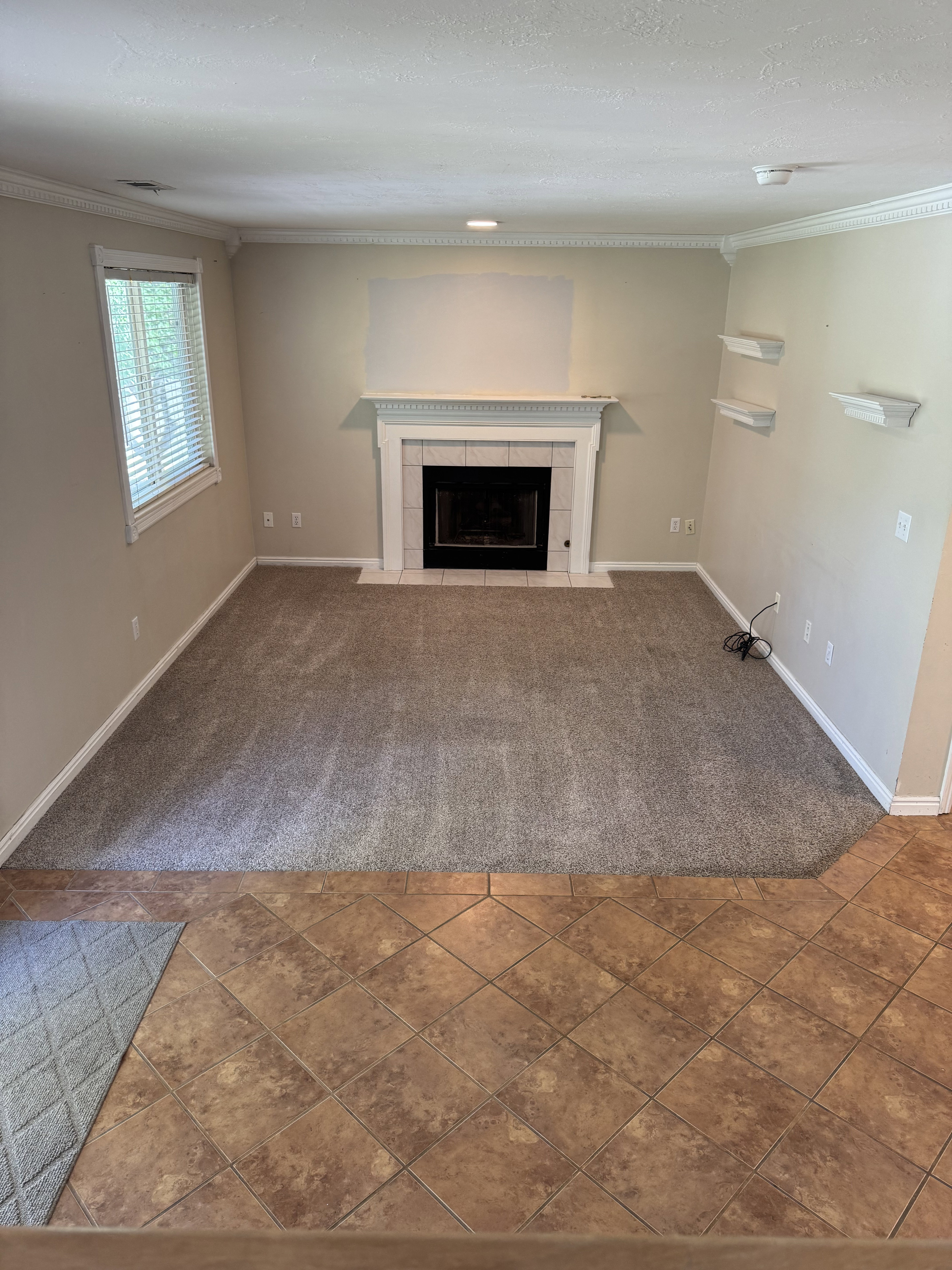 Living area featuring a tiled fireplace with mantel, recessed lighting, and crown molding