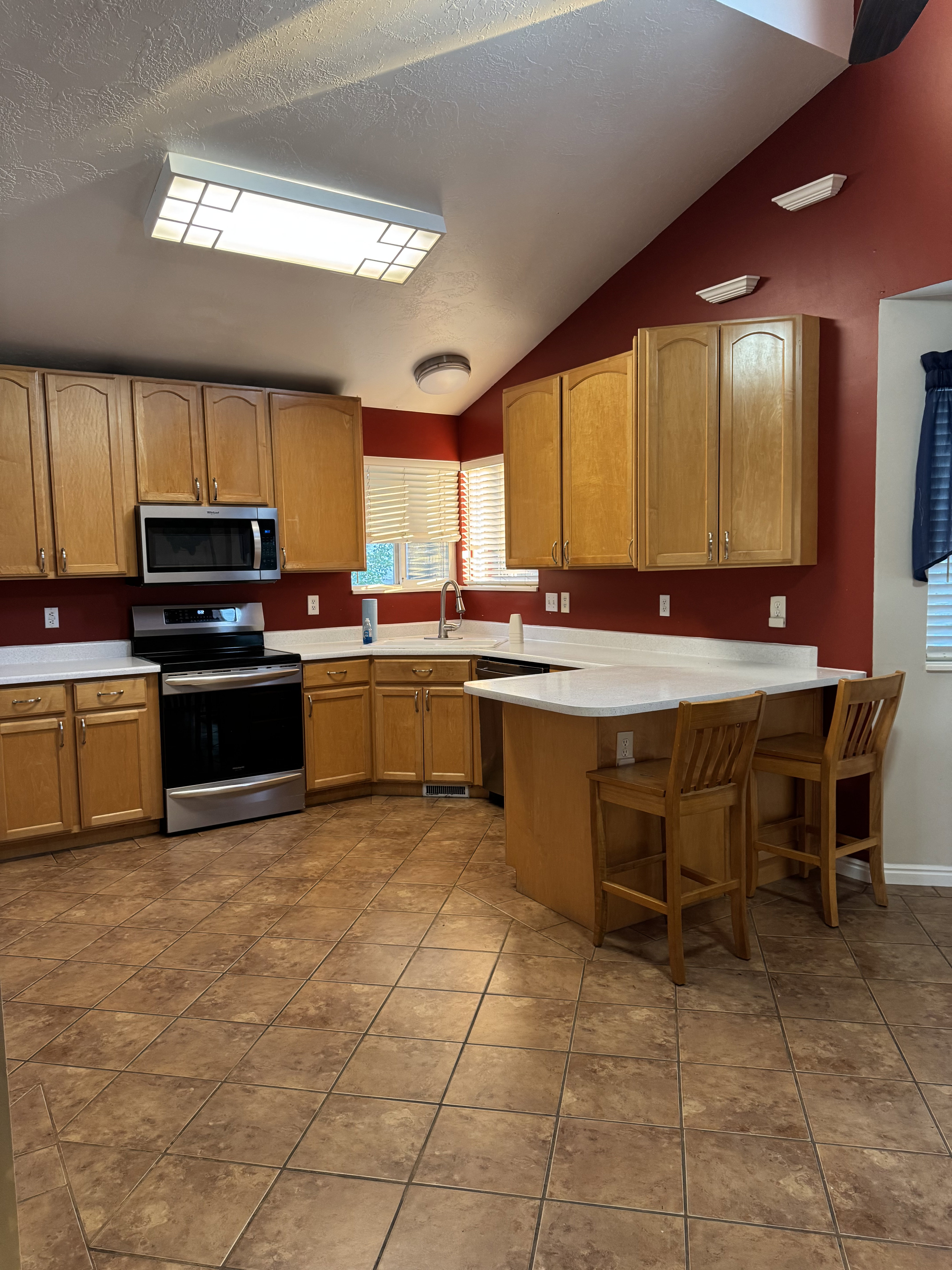 Kitchen featuring a vaulted ceiling and tile flooring