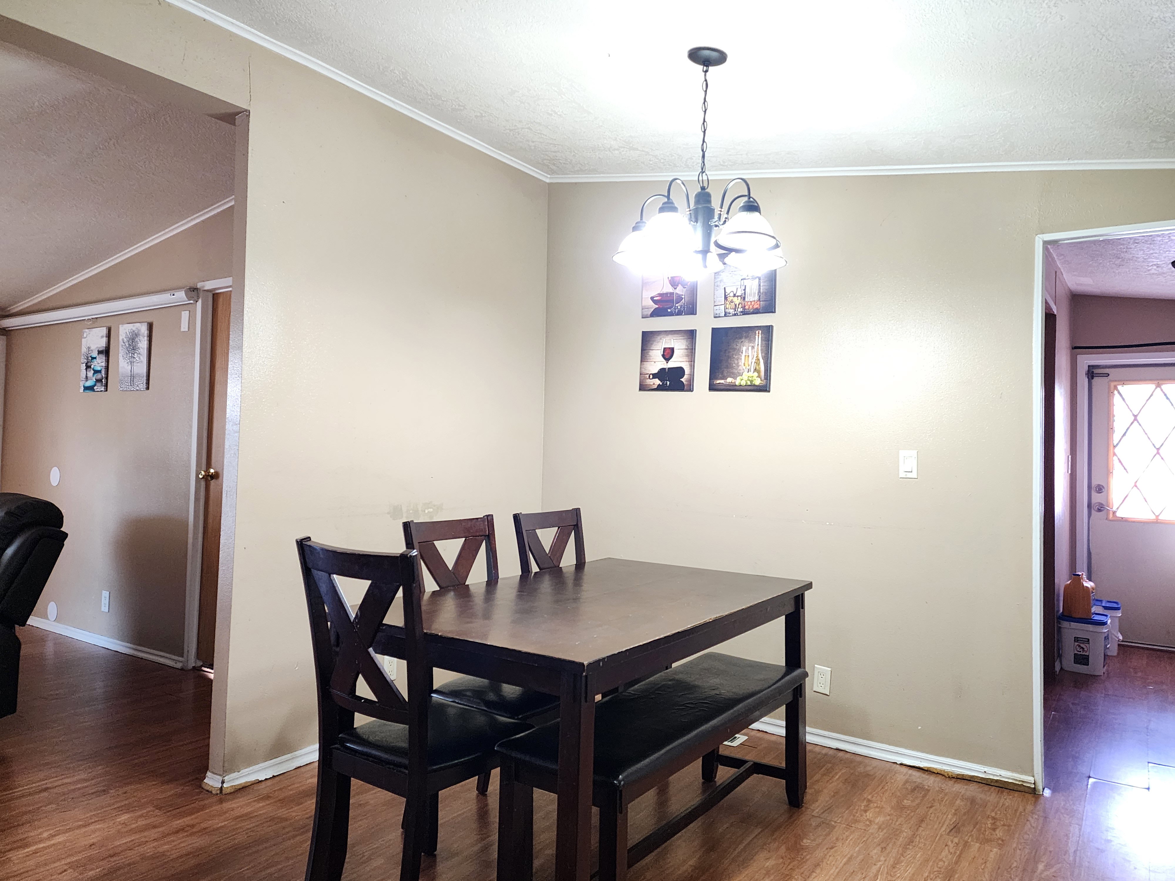 Dining area featuring wood-finish flooring, neutral wall tones, and crown molding
