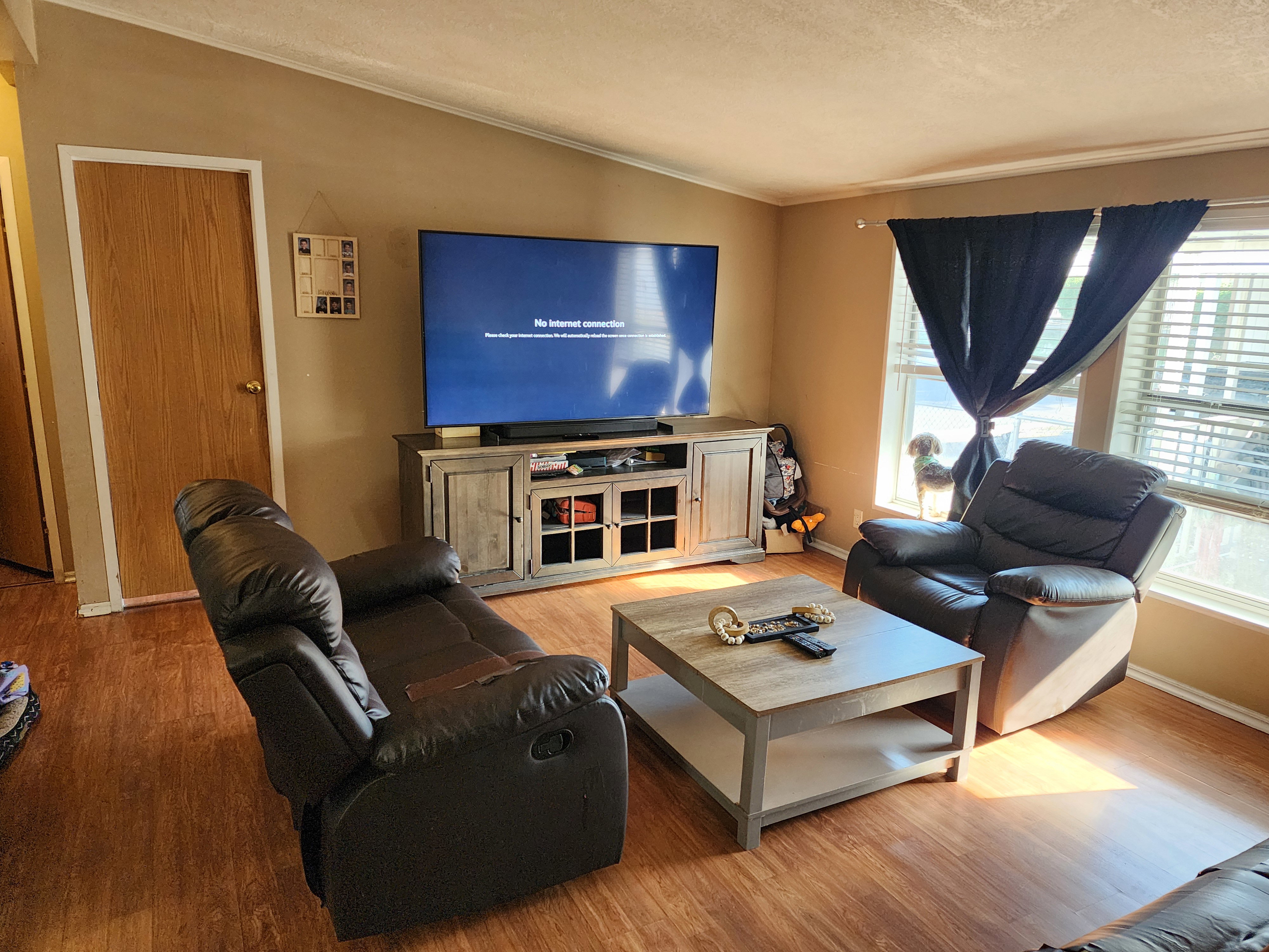 Living area featuring wood-finish flooring, warm-toned wall paint, and a white ceiling with crown molding
