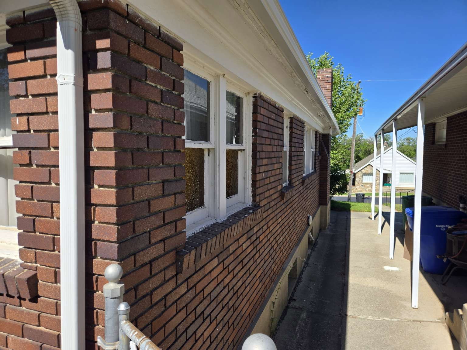 Brick exterior with white window frames and white gutters