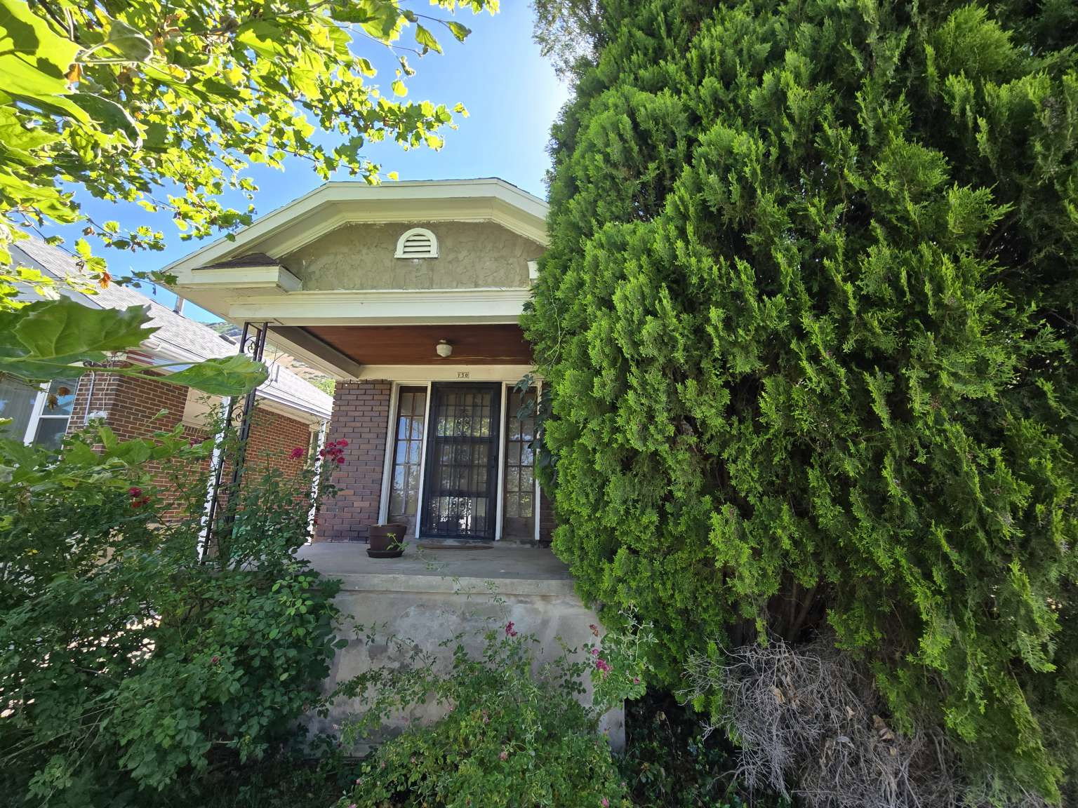 Stucco and brick facade with a covered front porch and mature landscaping