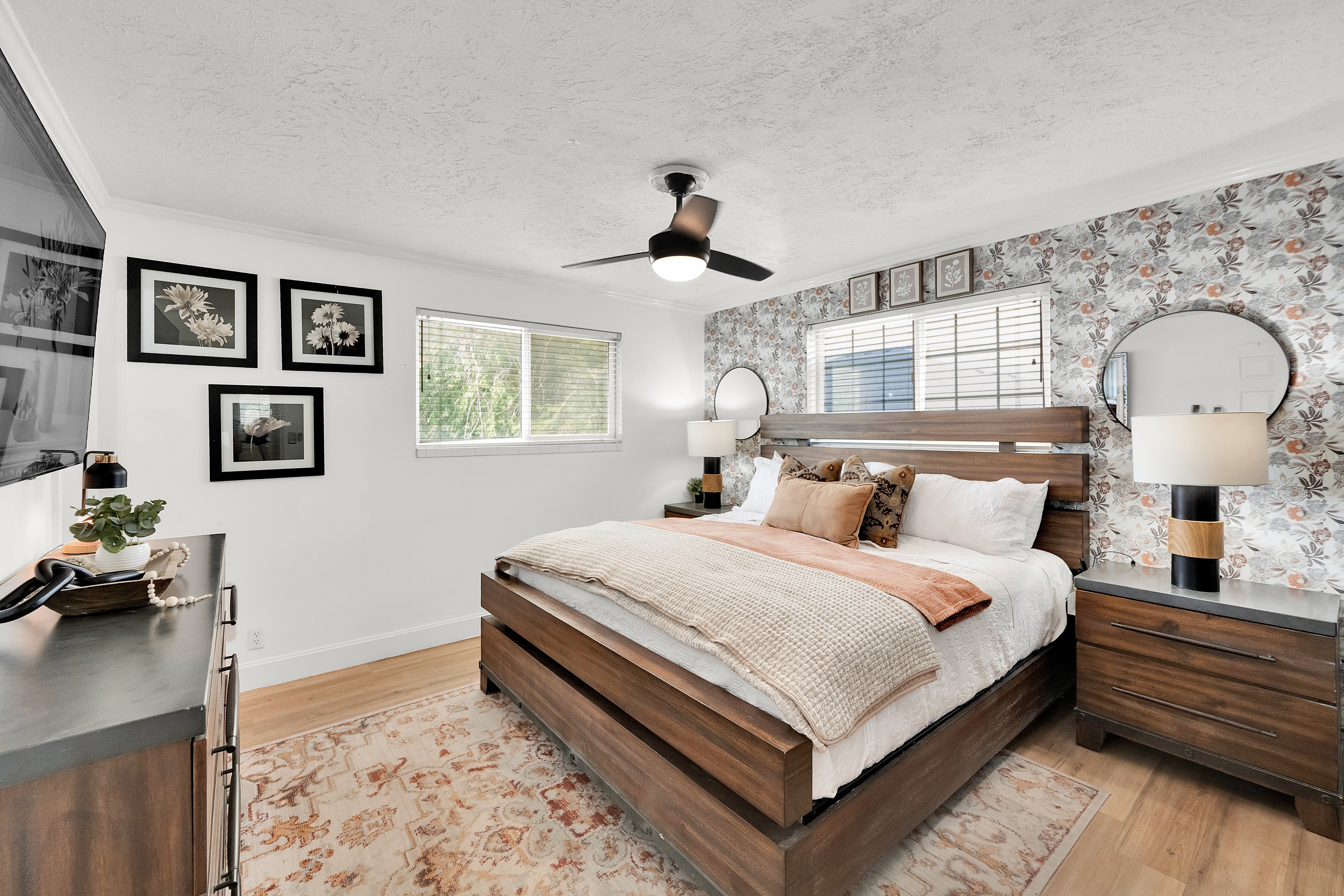 Bedroom featuring wood-finish flooring and a floral accent wall