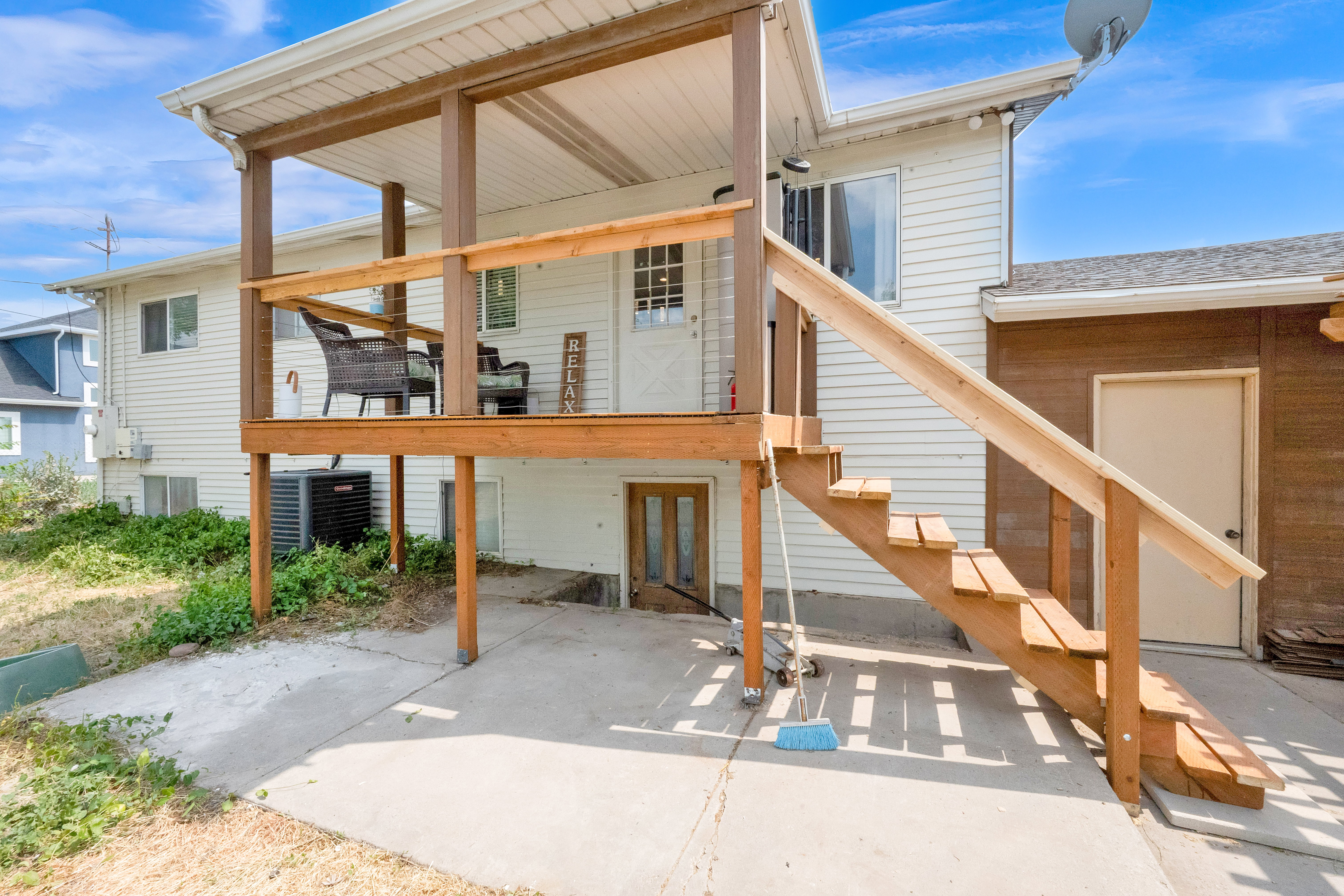 Outdoor covered deck with wood railing, supported by timber posts