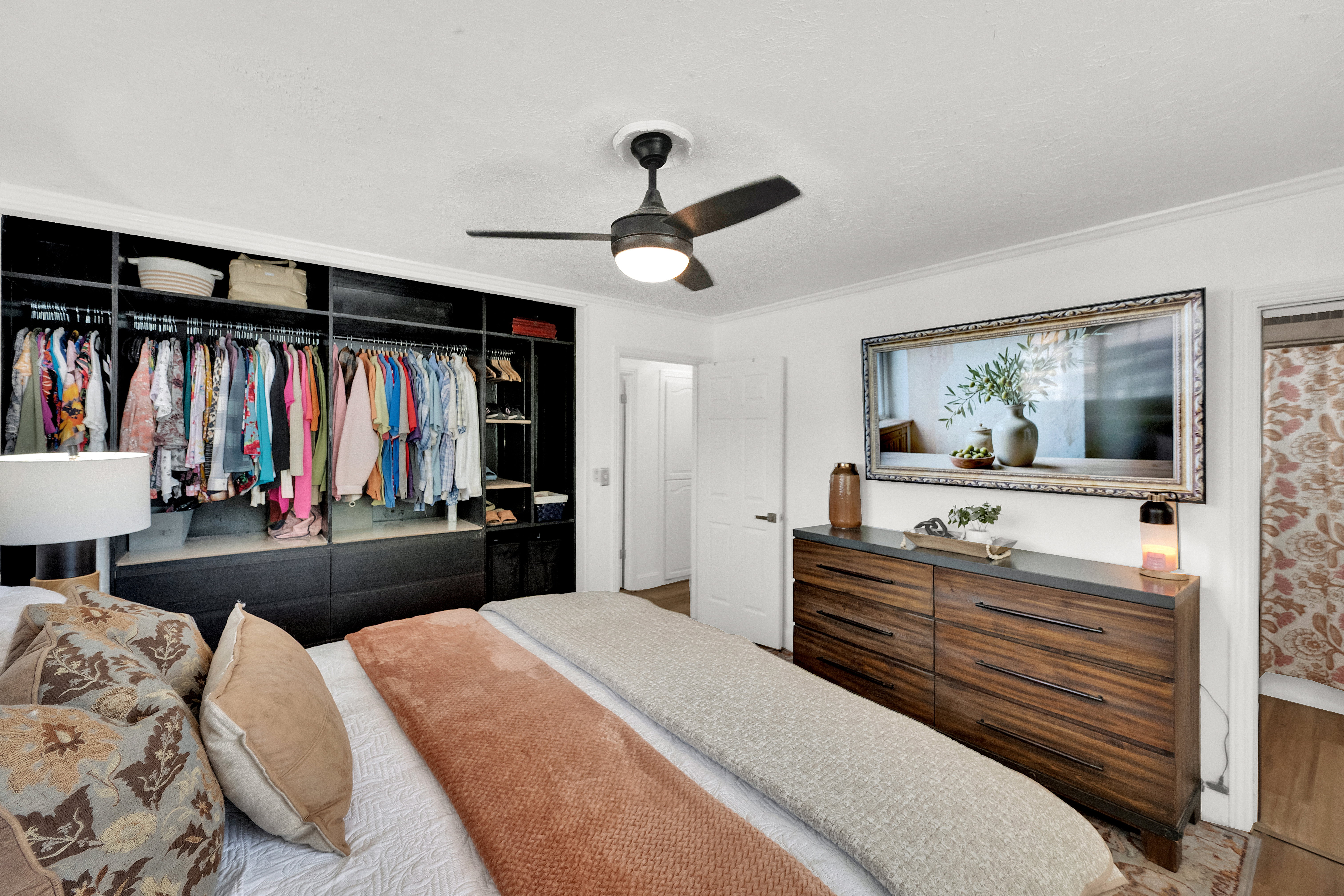 Bedroom featuring a built-in closet system with open shelving and drawer storage