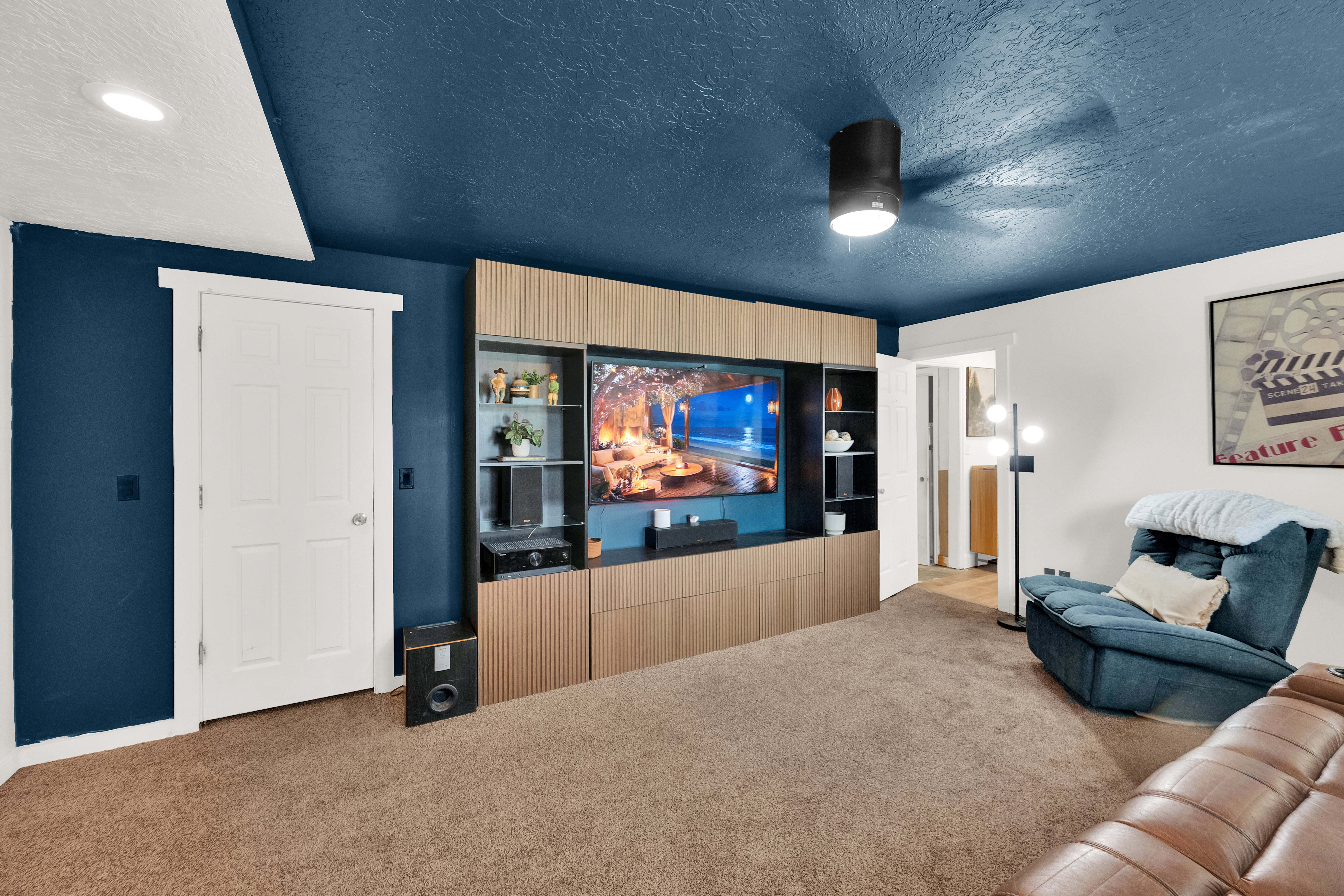 Custom built-in media center with integrated shelving and storage, contrasting against blue walls and a matching ceiling