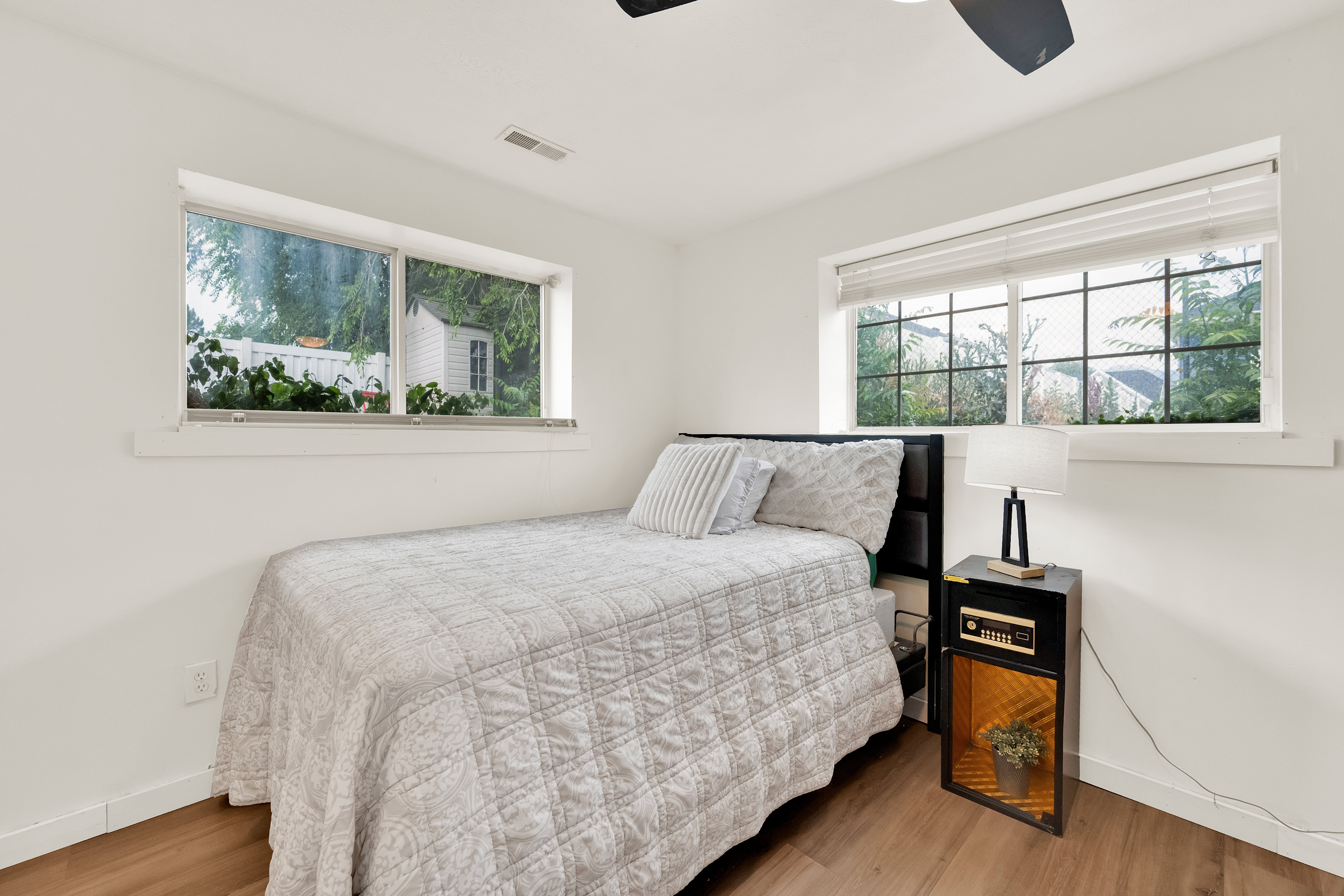 Bright interior space featuring wood-finish flooring, white walls, and a ceiling fan