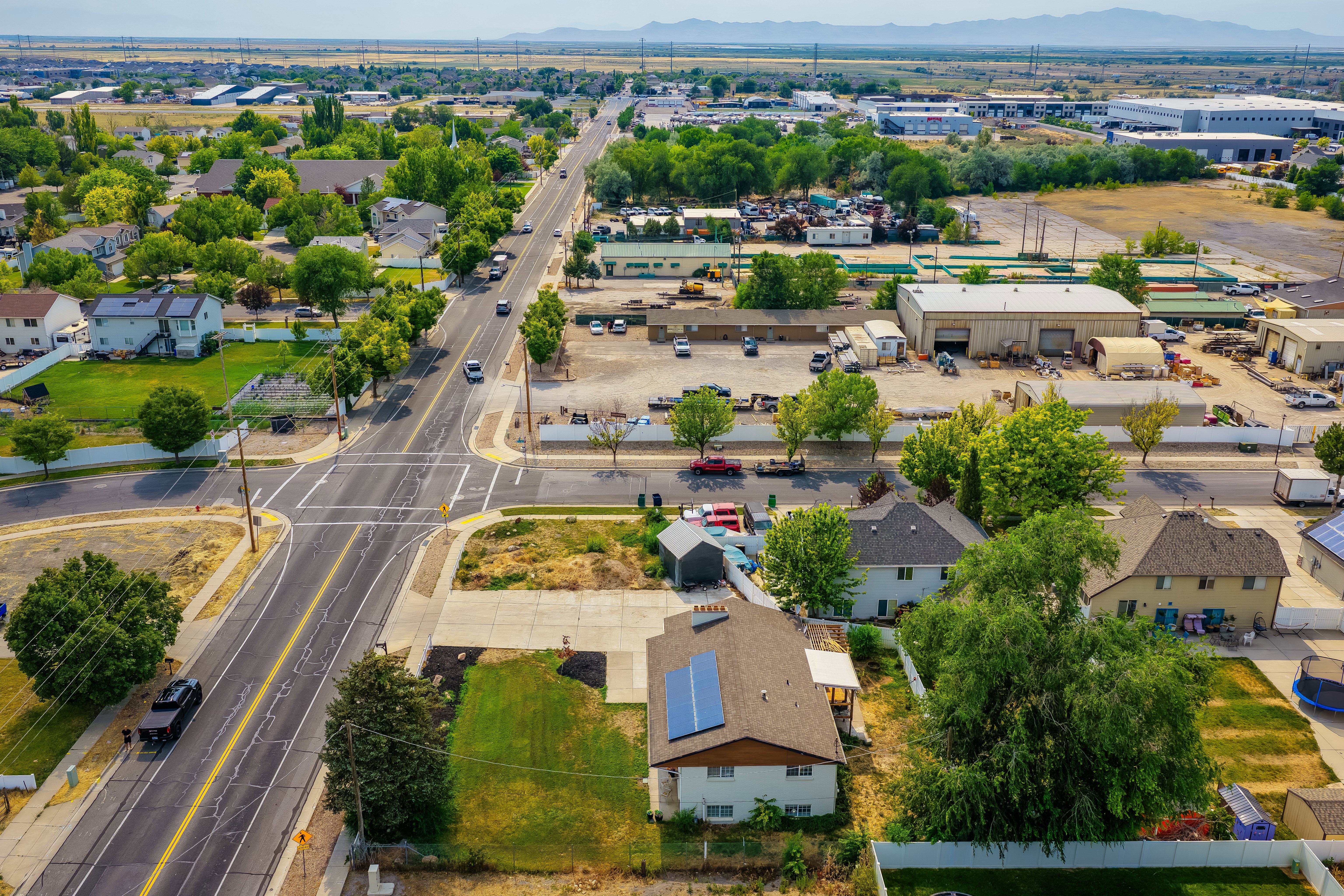 Aerial perspective of a developed residential and commercial area with visible mountains in the distance