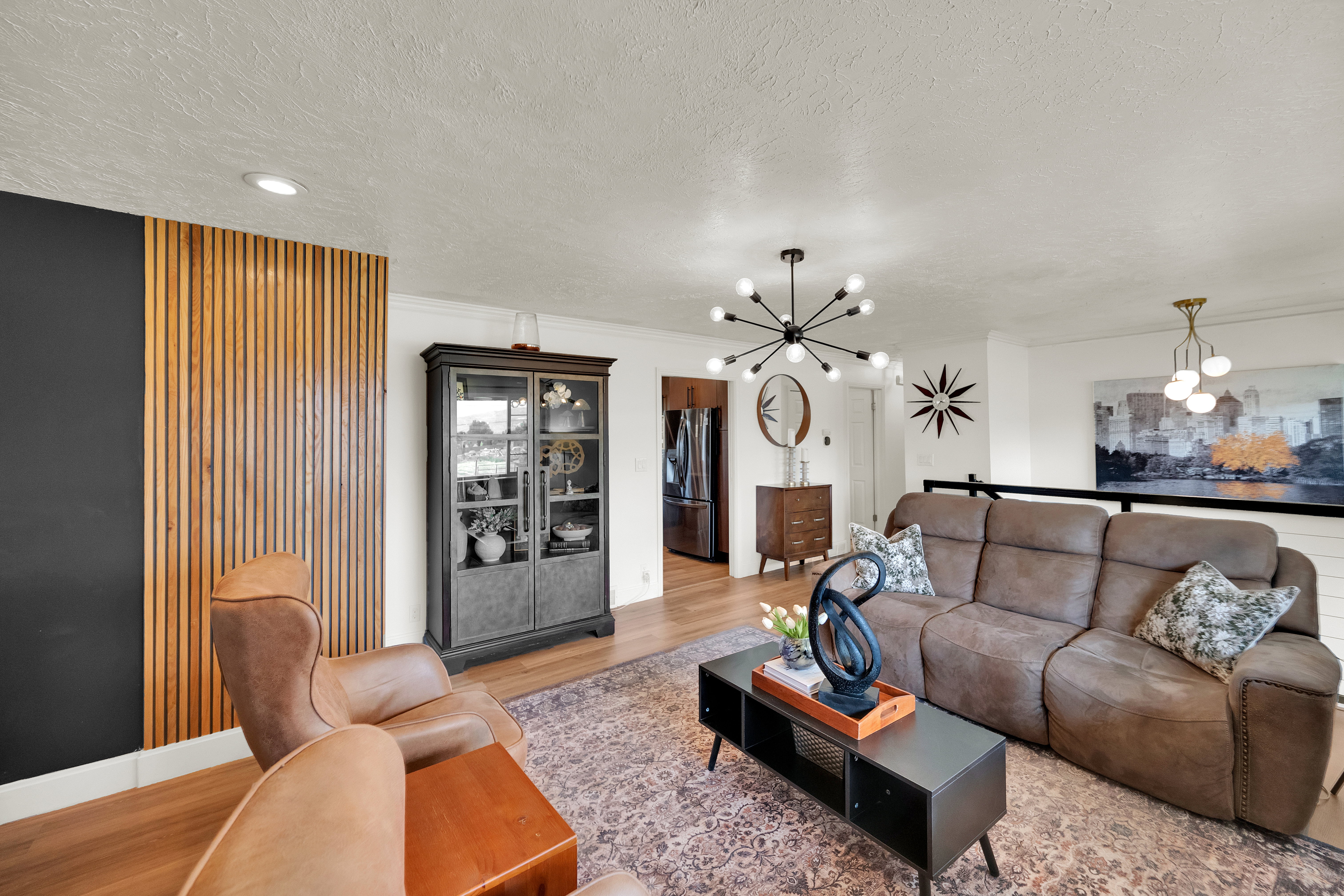 Spacious living area featuring wood-finish flooring, a contemporary black sputnik chandelier, and recessed lighting