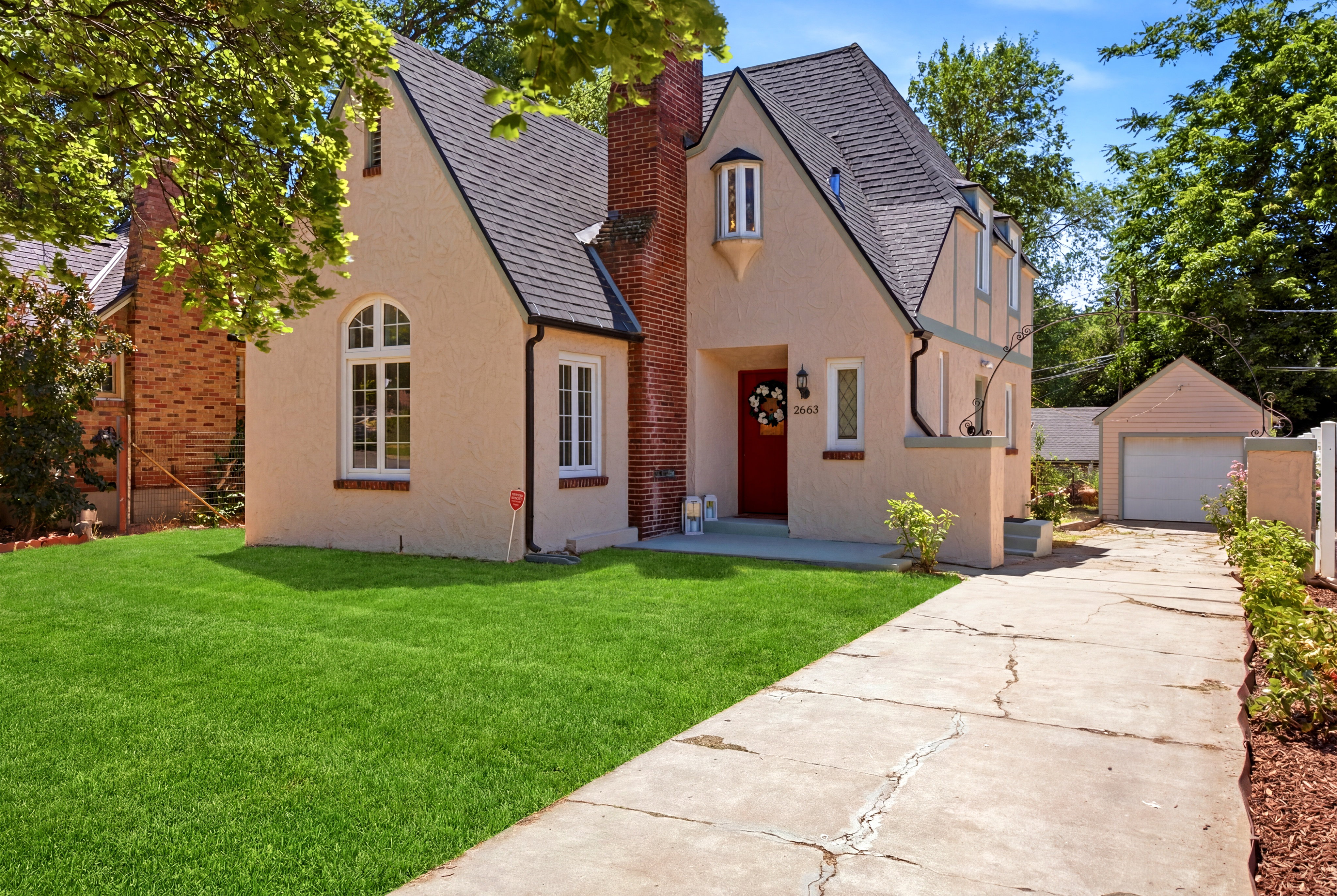 Charming stucco exterior with a prominent red entry door and an arched window detail