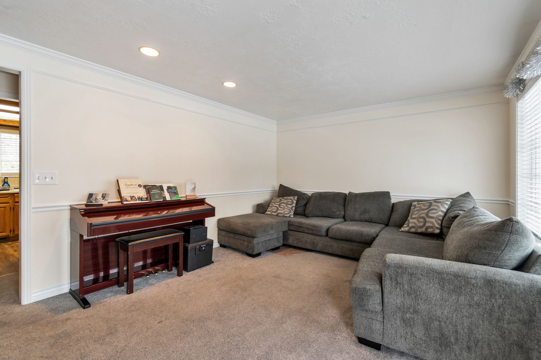 Carpeted living area featuring recessed lighting and crown molding
