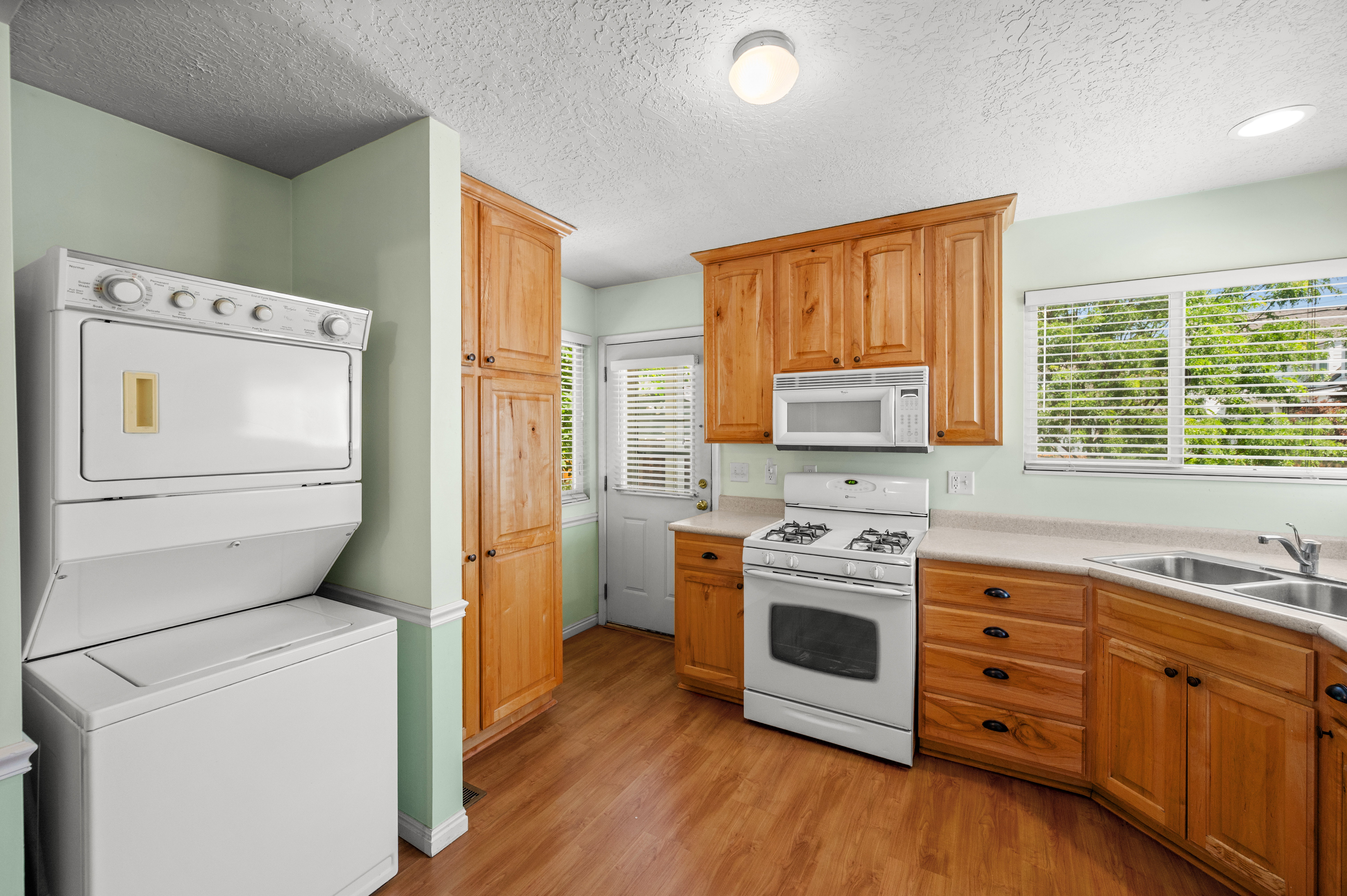 Kitchen featuring wood-finish flooring and light wood cabinetry