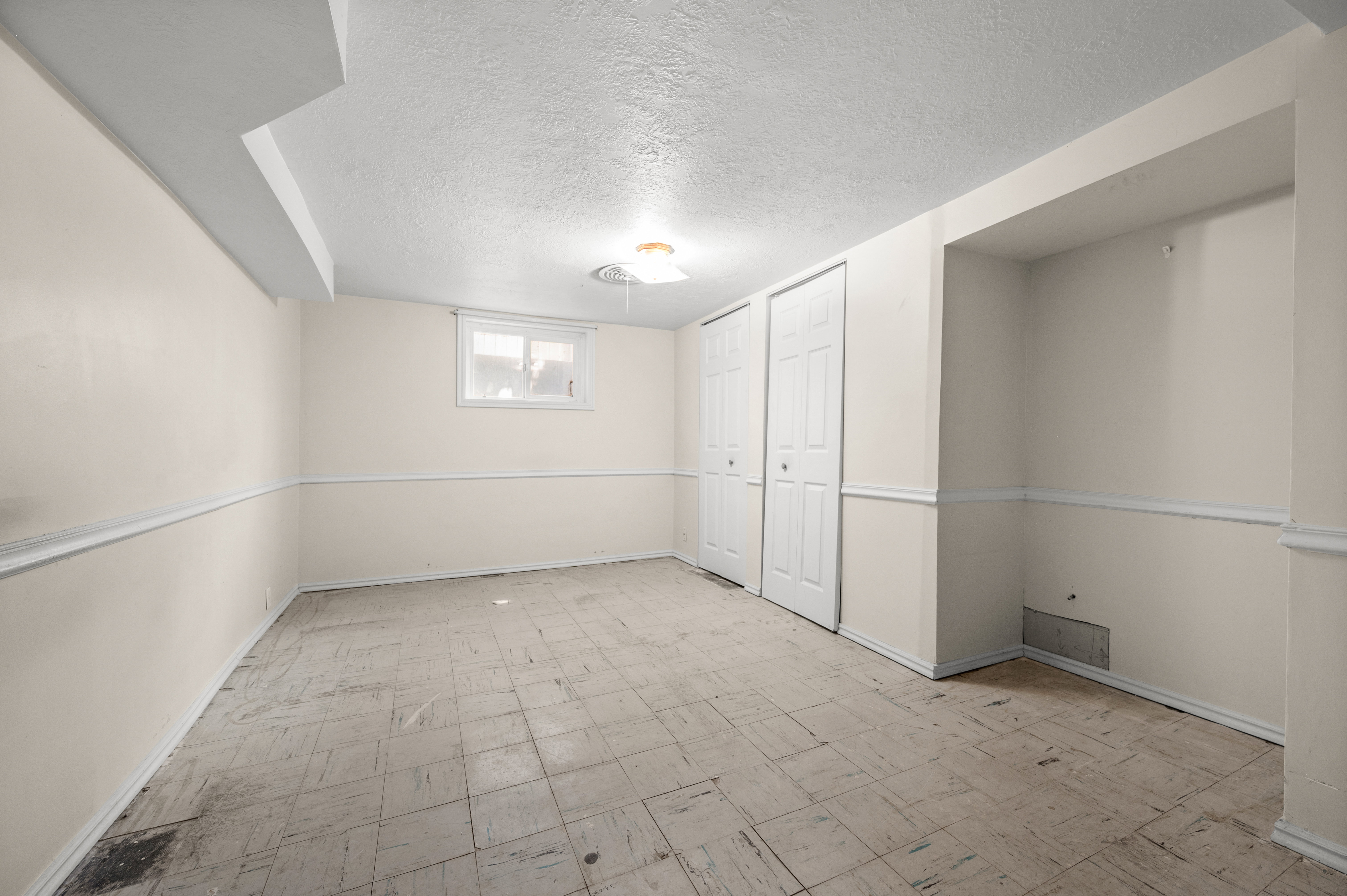 Room featuring light-colored walls, white baseboards, and chair rail molding