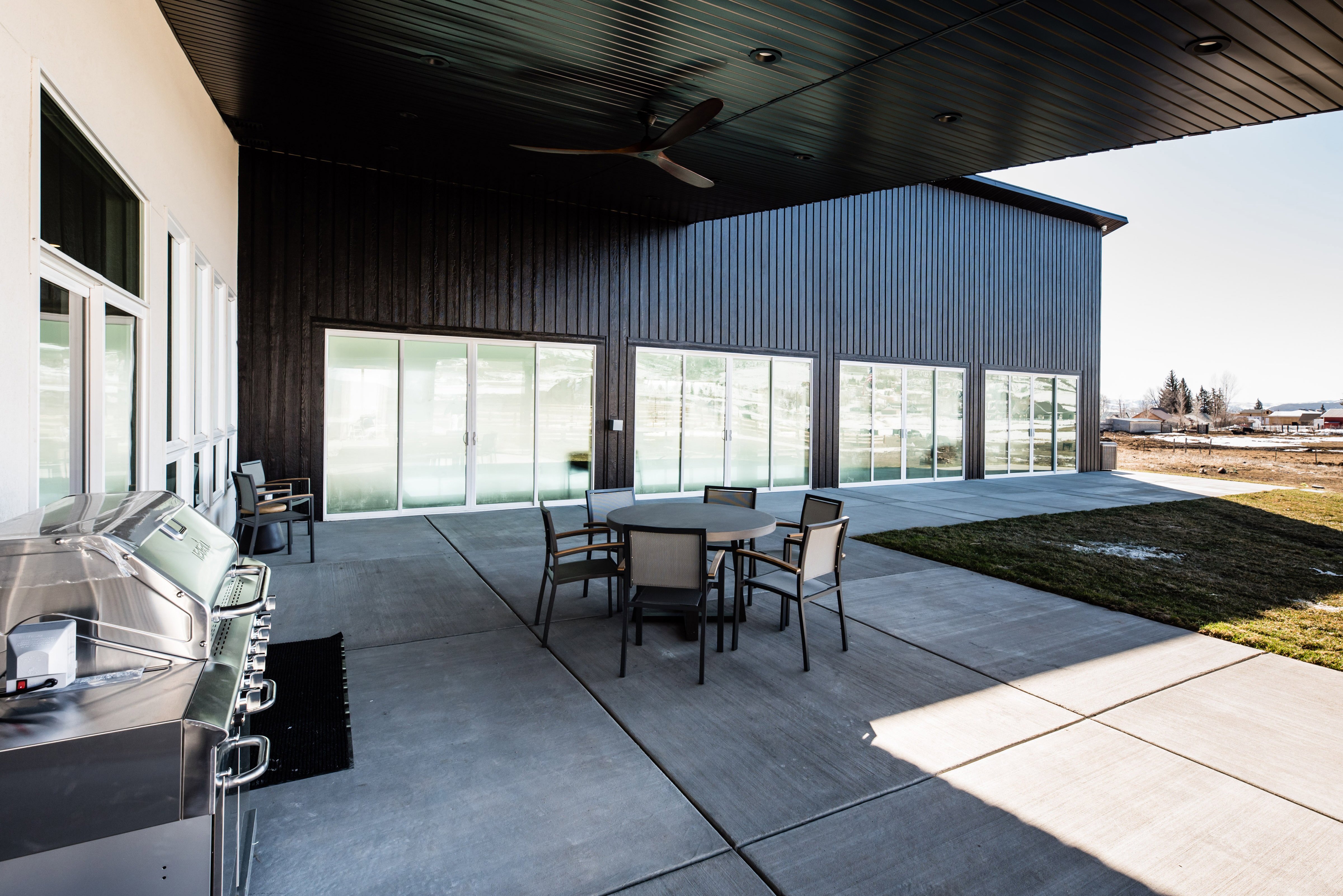 Expansive concrete patio featuring a built-in stainless steel grill