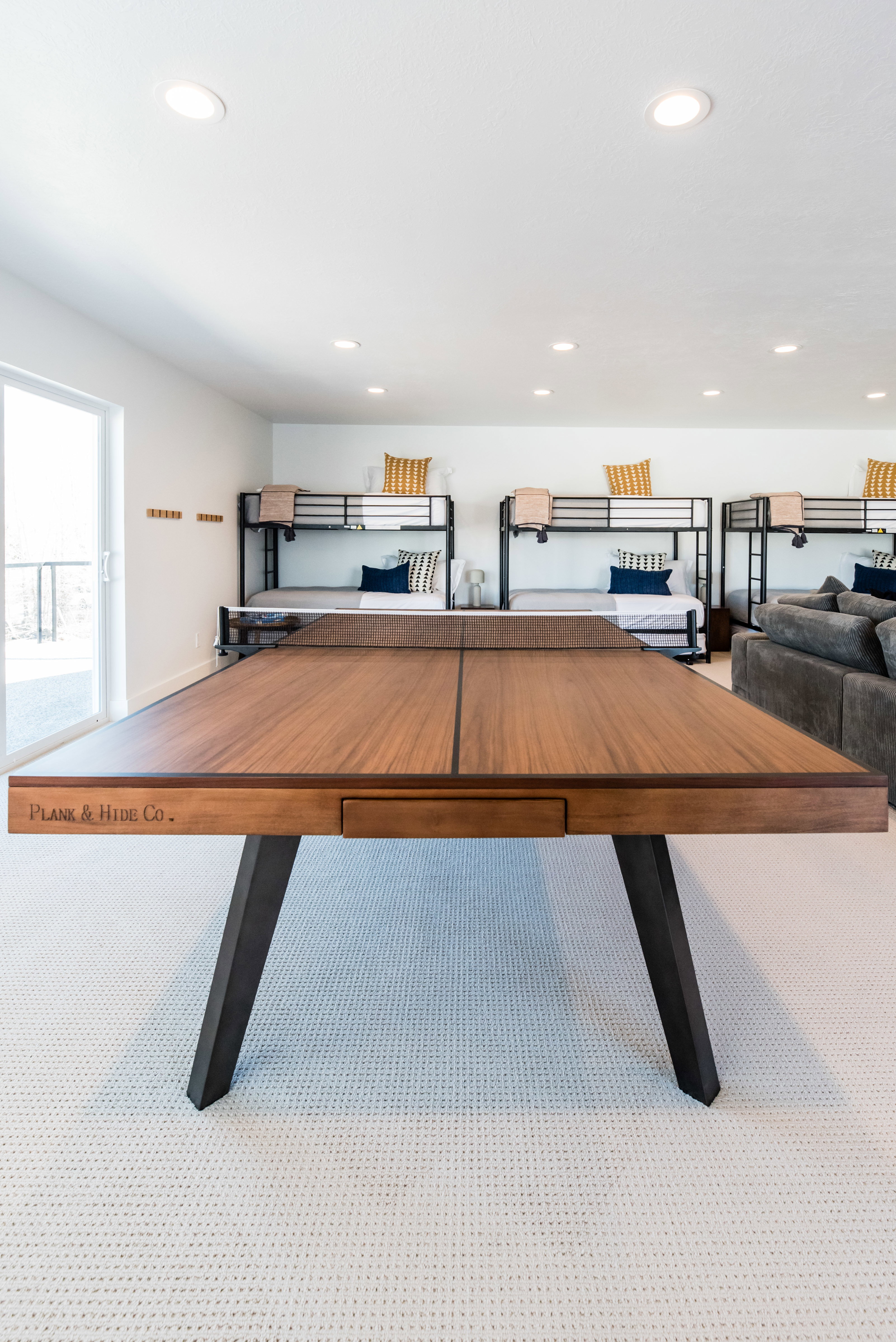 Versatile entertainment room featuring textured carpet flooring, recessed lighting, and a sliding glass door