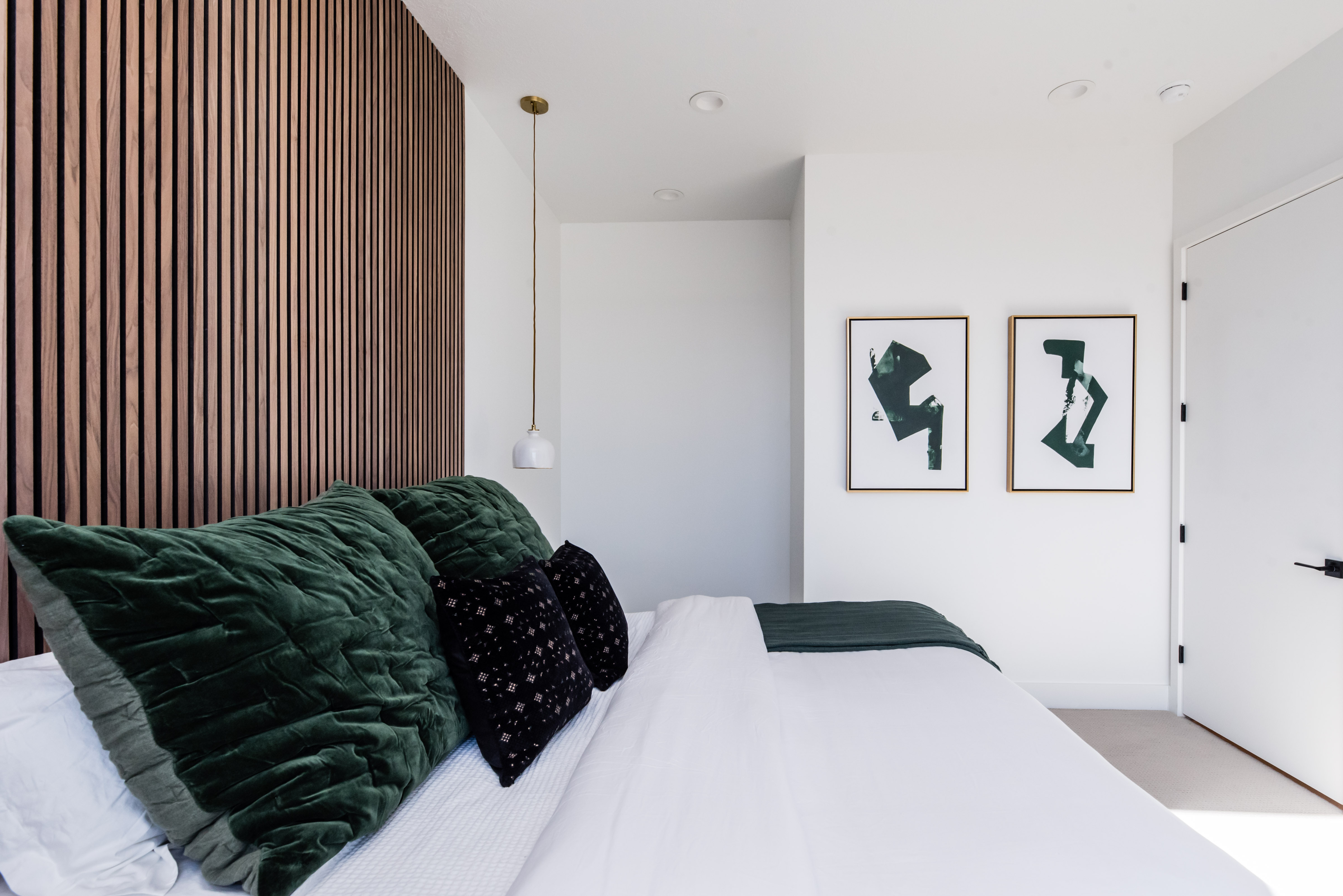 Accent wall featuring vertical wood paneling, recessed lighting, and a modern pendant light