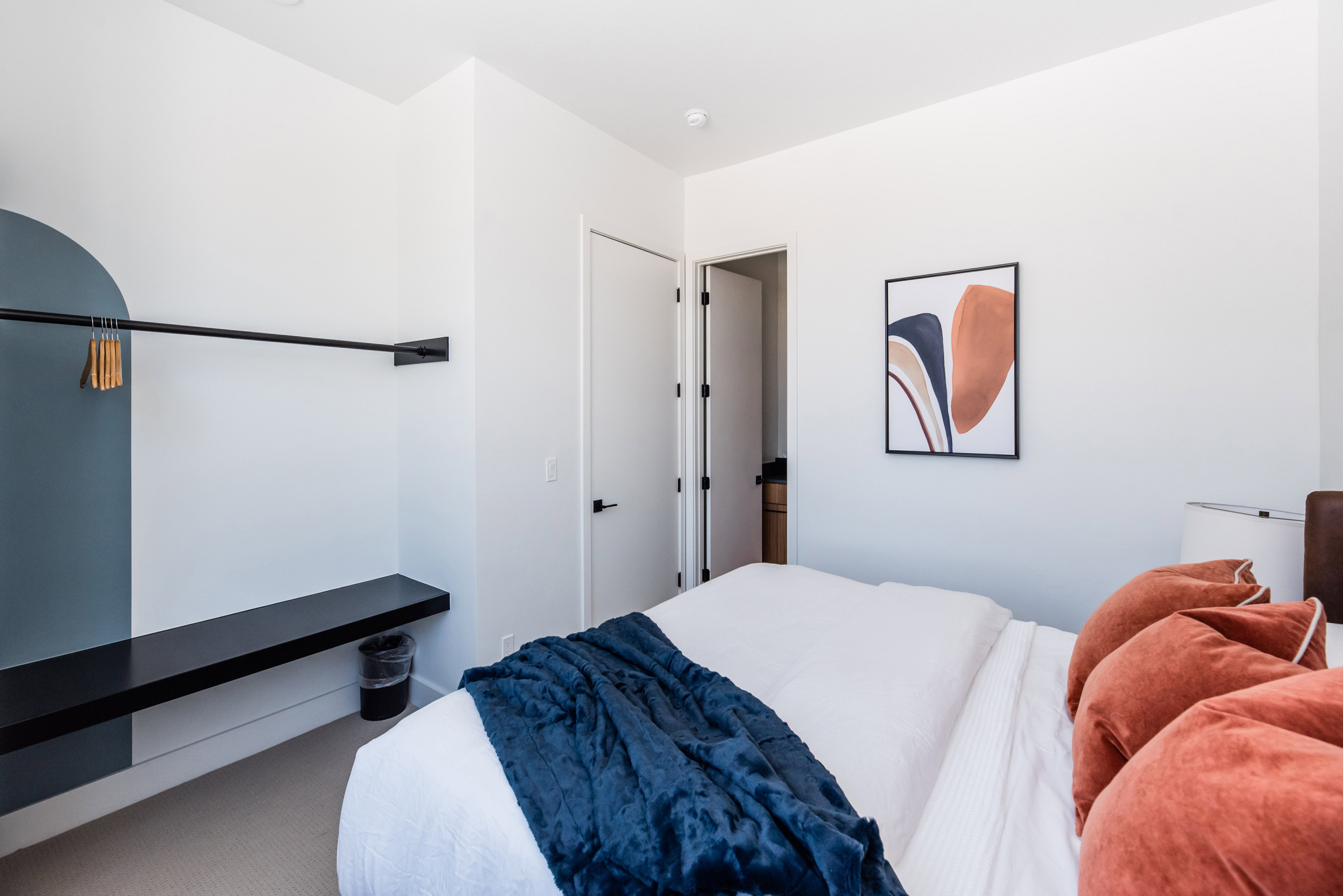 Contemporary bedroom featuring light-colored walls and carpeted flooring