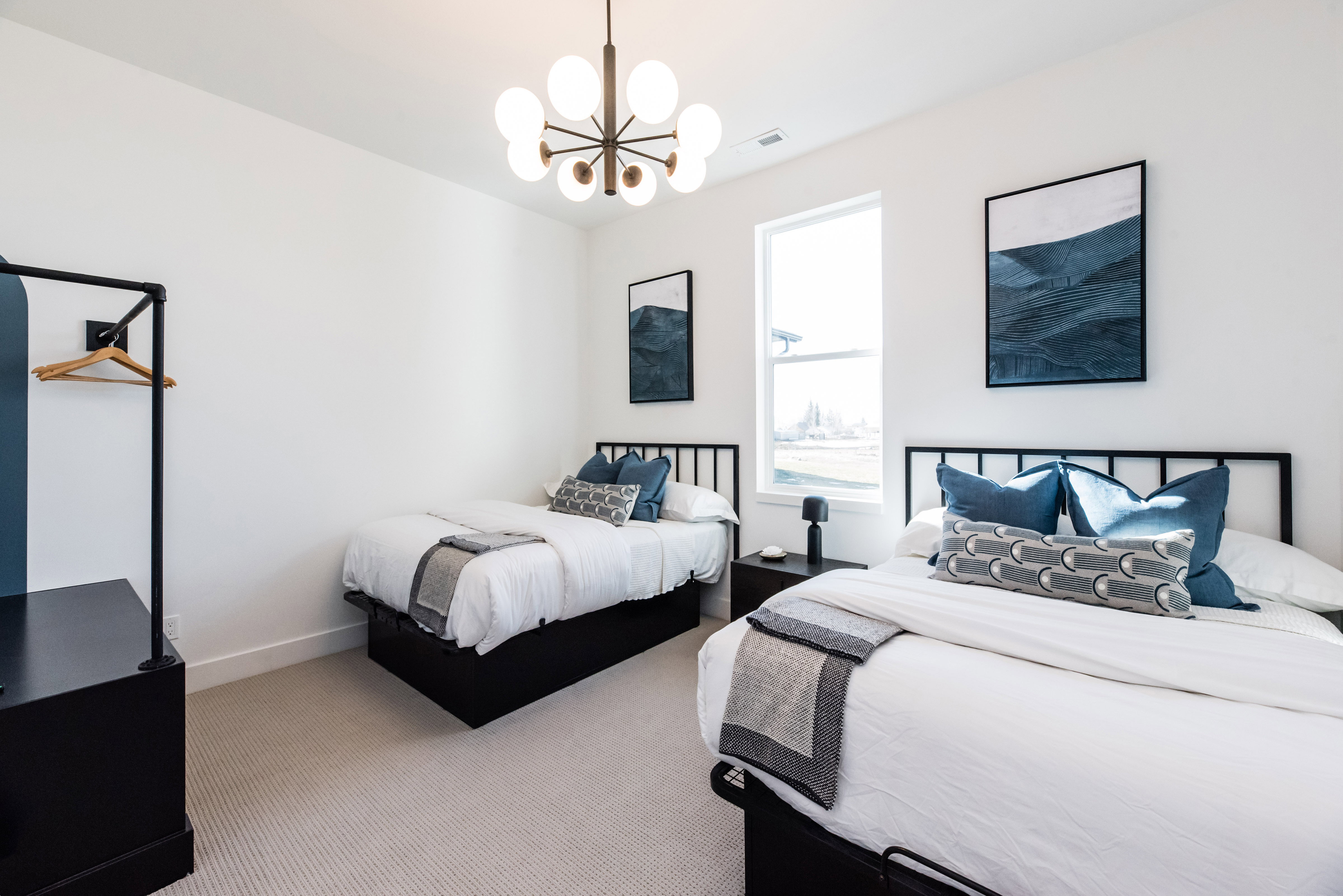Light-filled room featuring a large window, carpeted flooring, and a modern ceiling light fixture