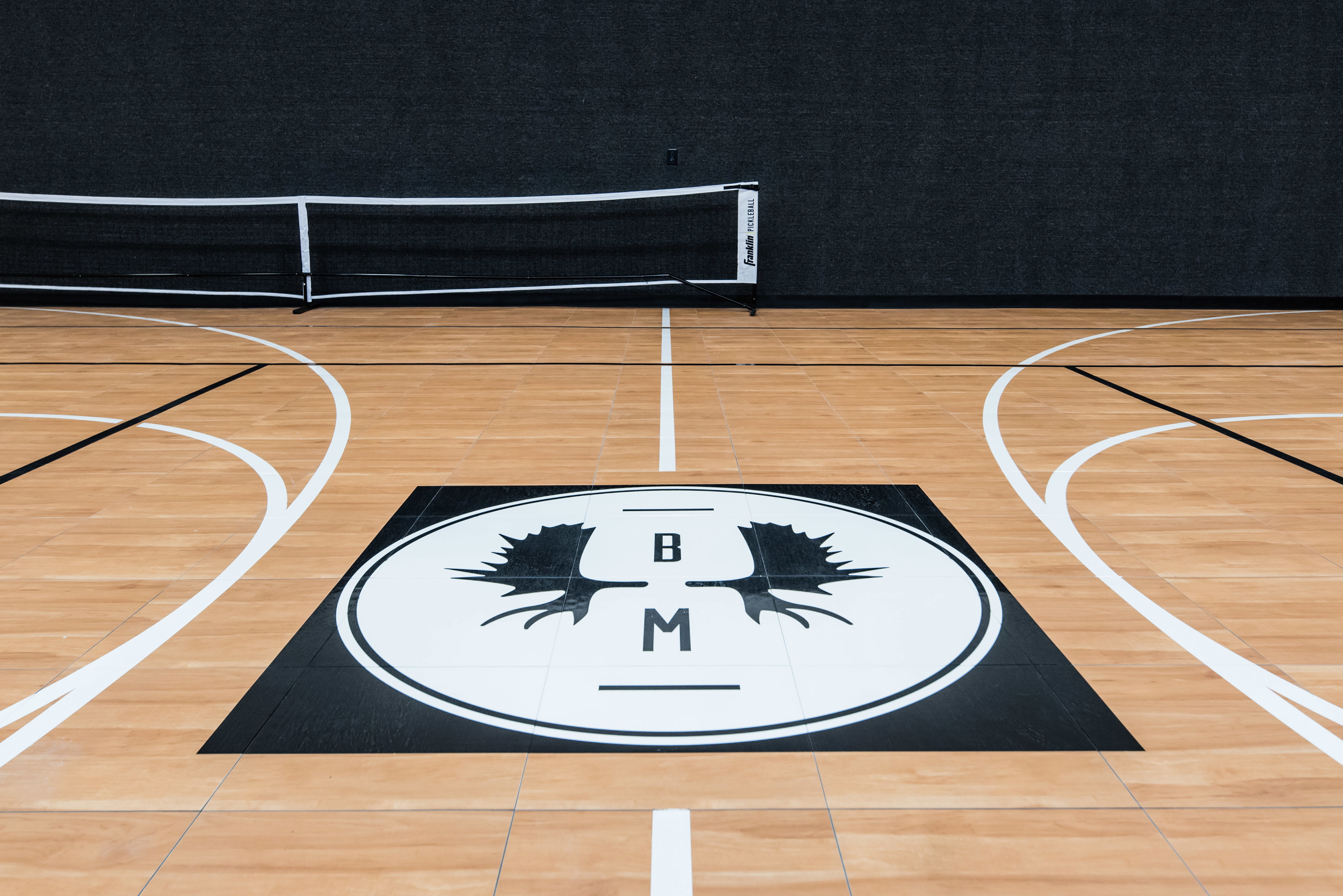 Indoor court featuring wood-finish flooring with court markings