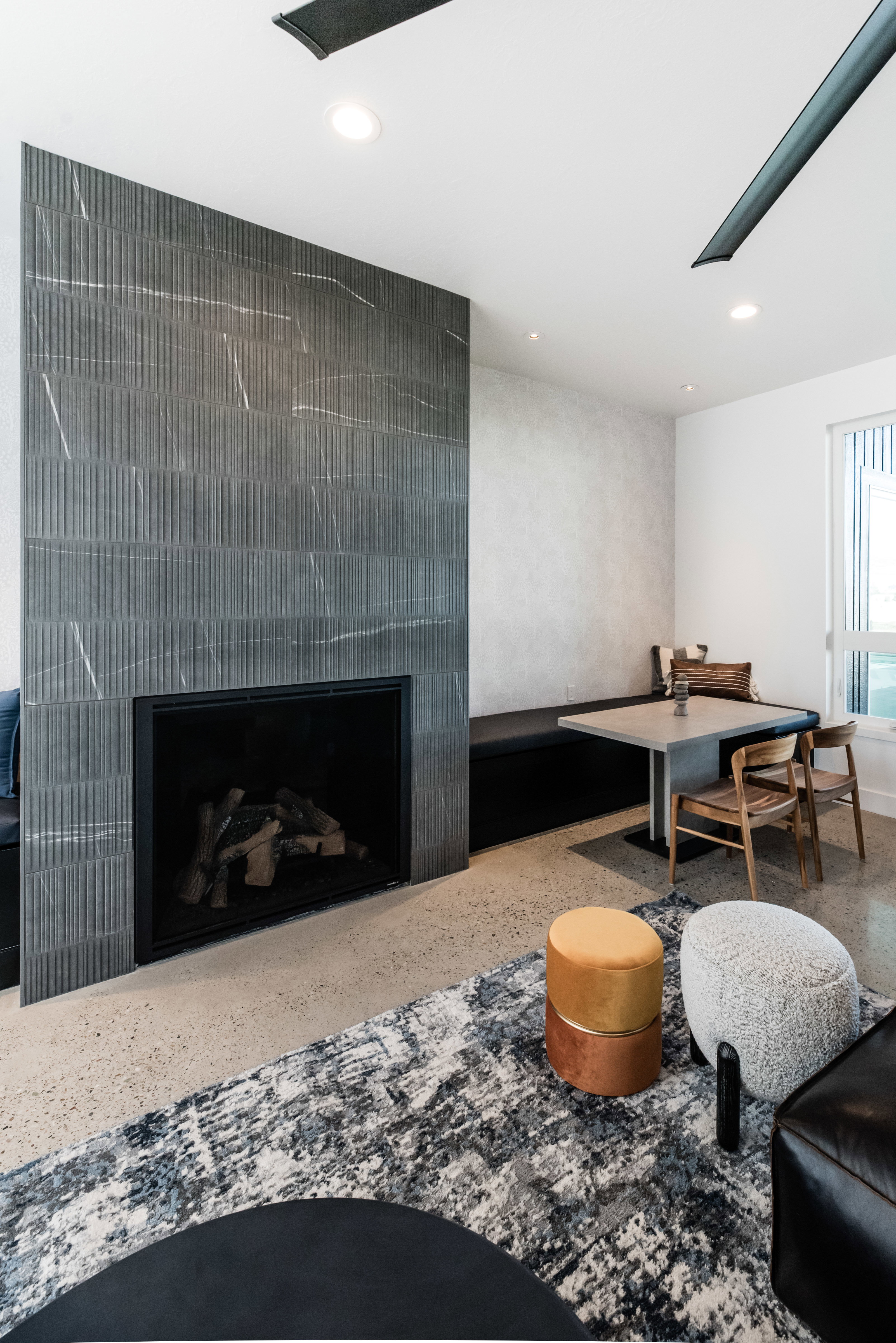 Floor-to-ceiling fireplace featuring textured tile and a black surround