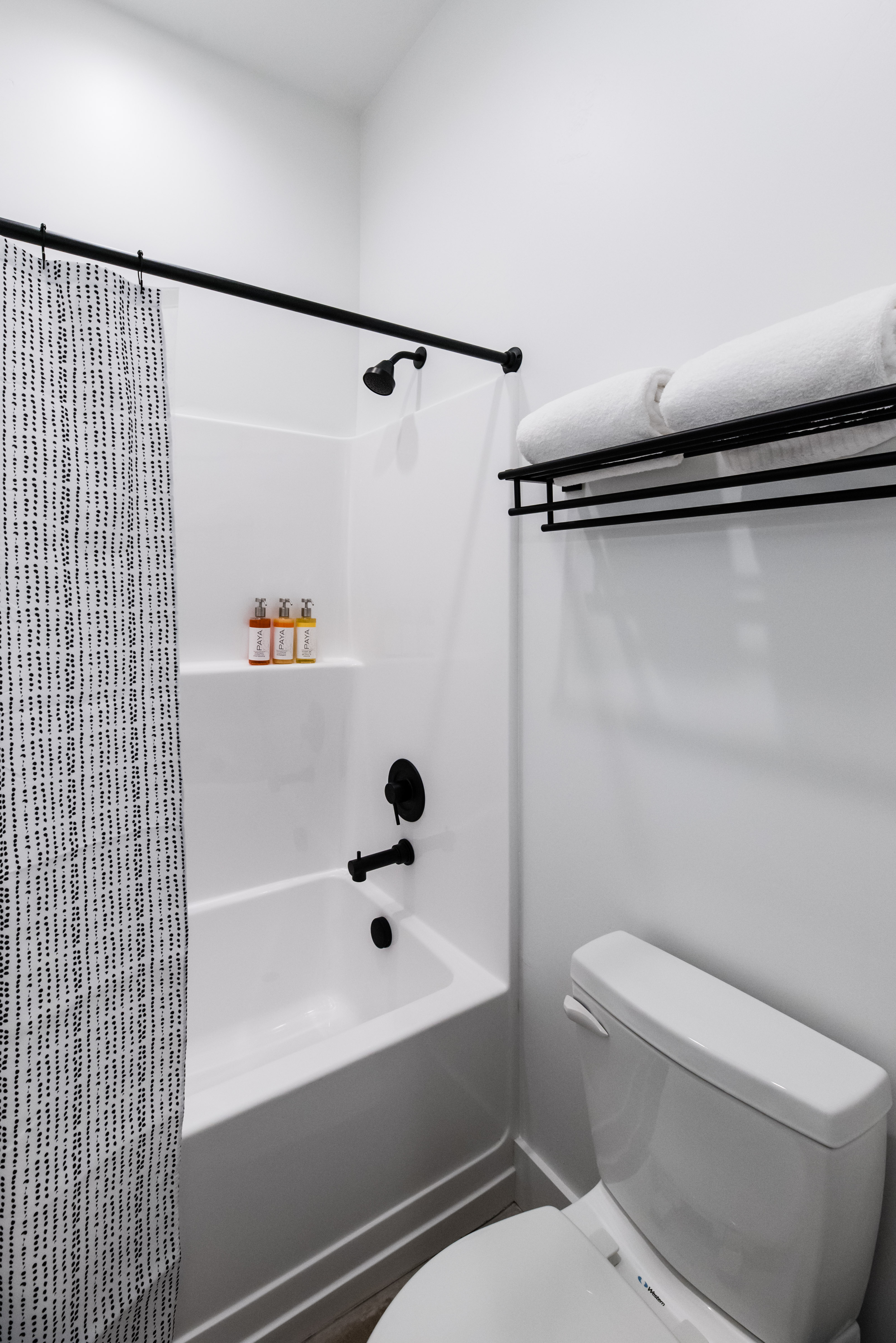 Bathroom featuring a white tub and shower combination with matte black fixtures