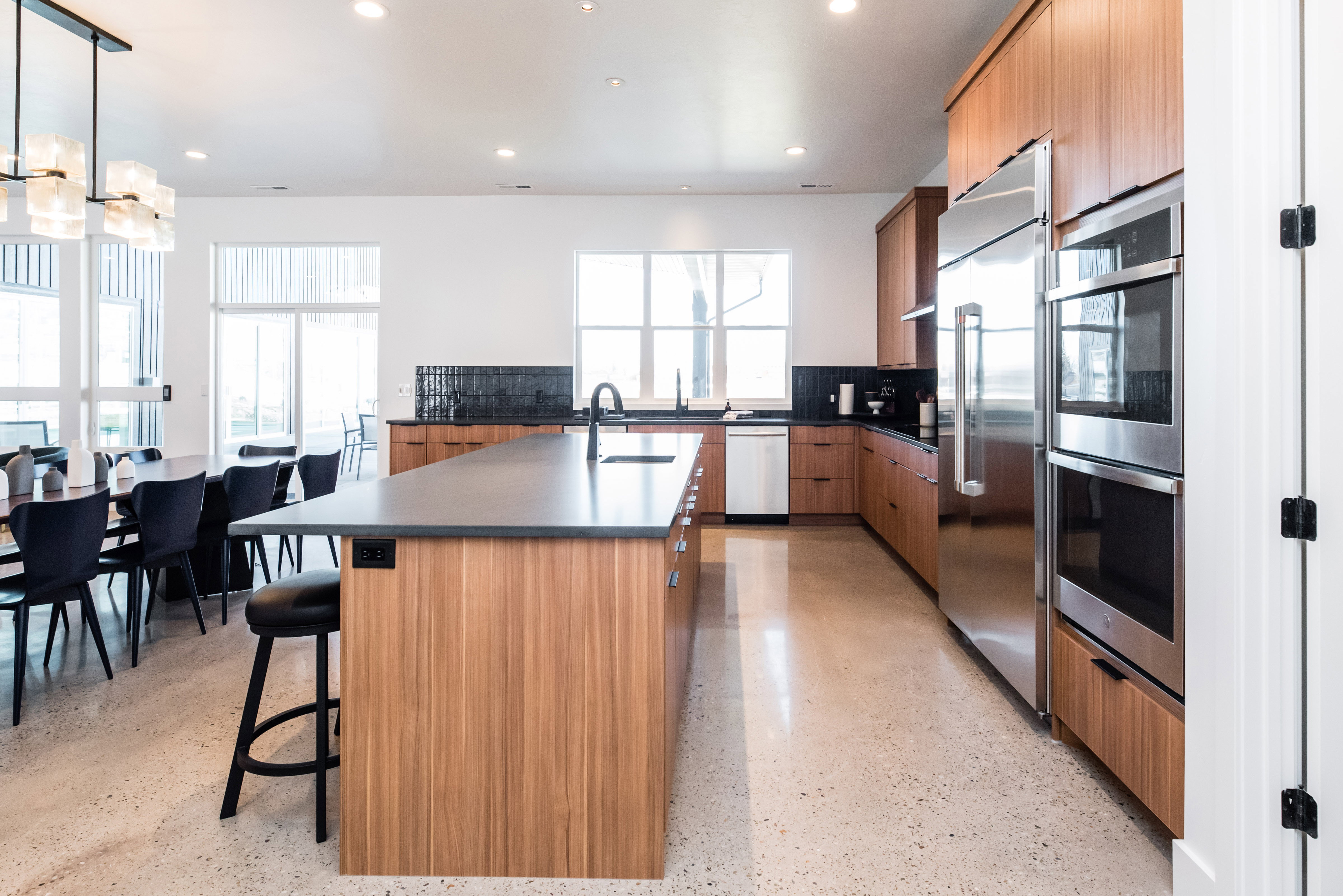 Modern kitchen featuring wood-finish cabinetry, stainless steel appliances, and a central island with a dark countertop
