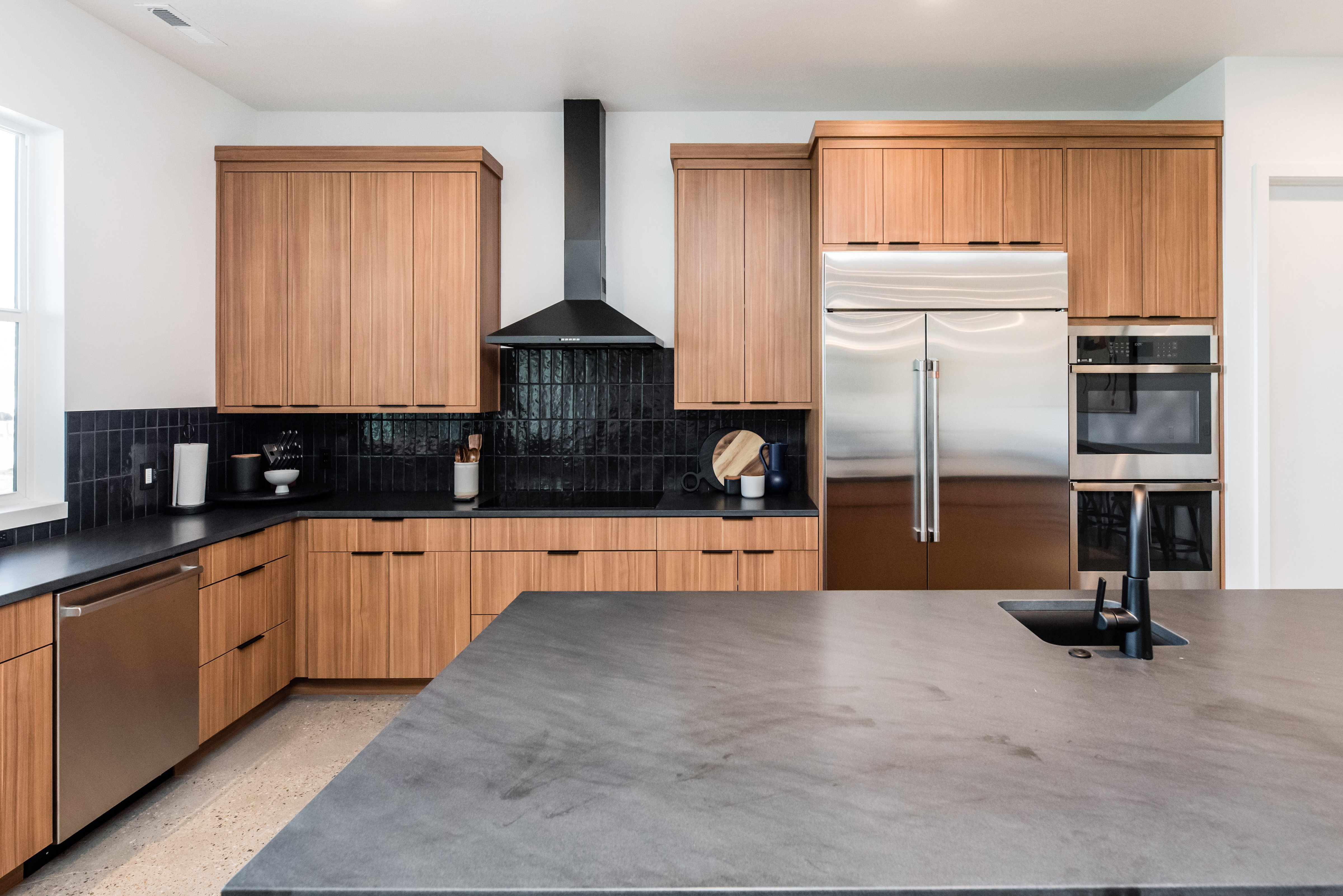 Modern kitchen featuring wood-finish cabinetry and dark countertops