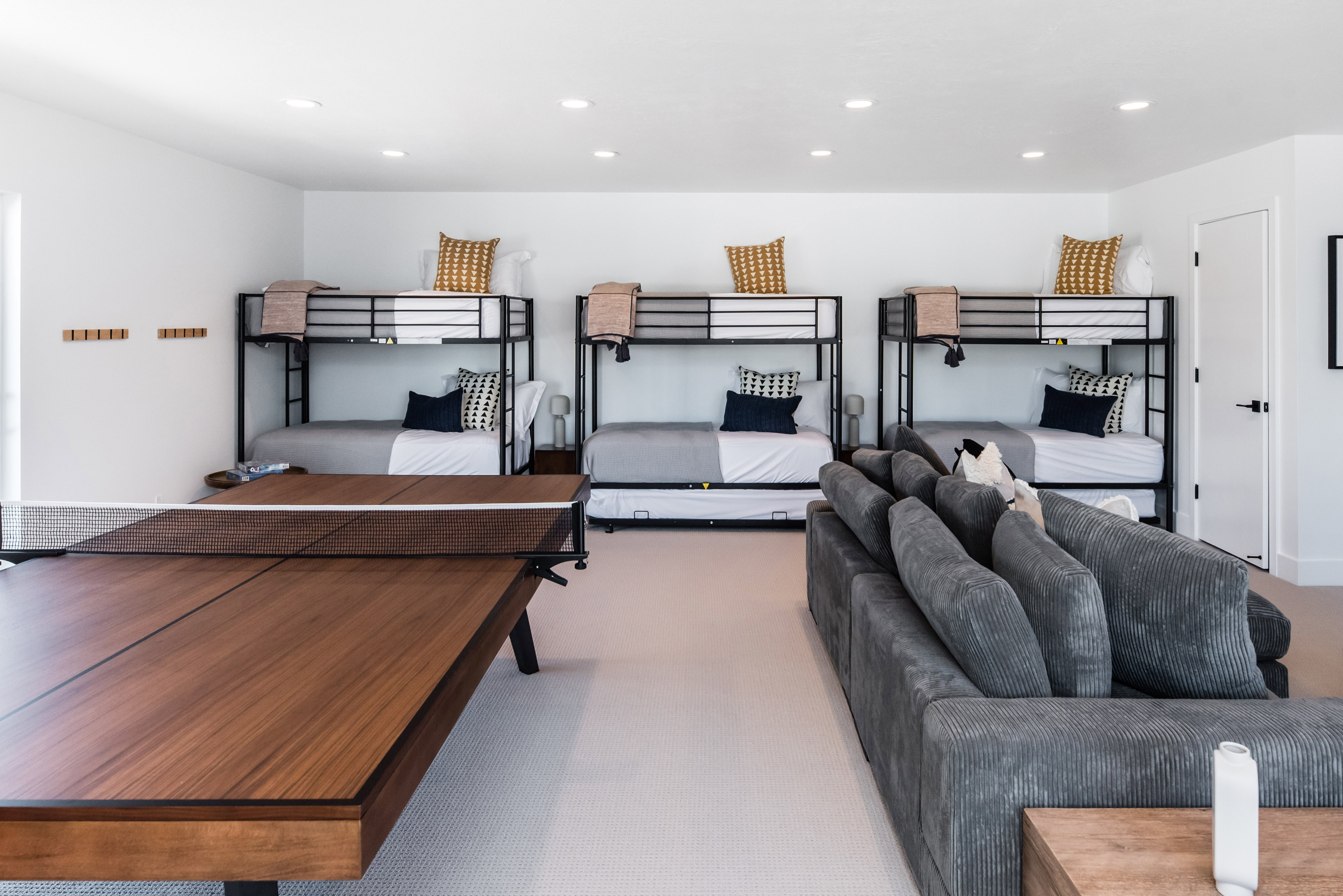 Spacious recreational room featuring a wood-finish game table and recessed lighting
