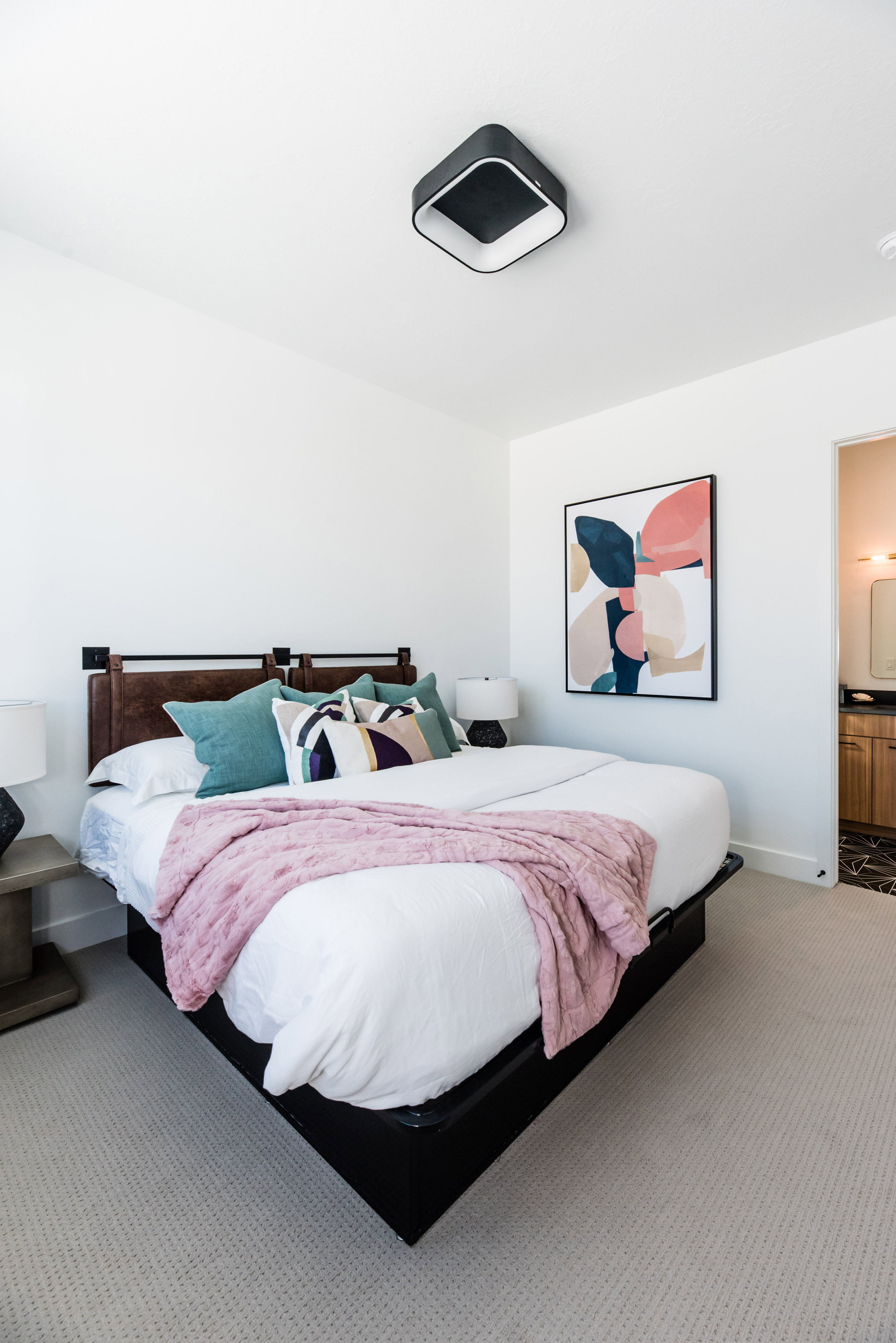 Neutral-toned carpeting extends throughout this room, featuring a modern ceiling light fixture