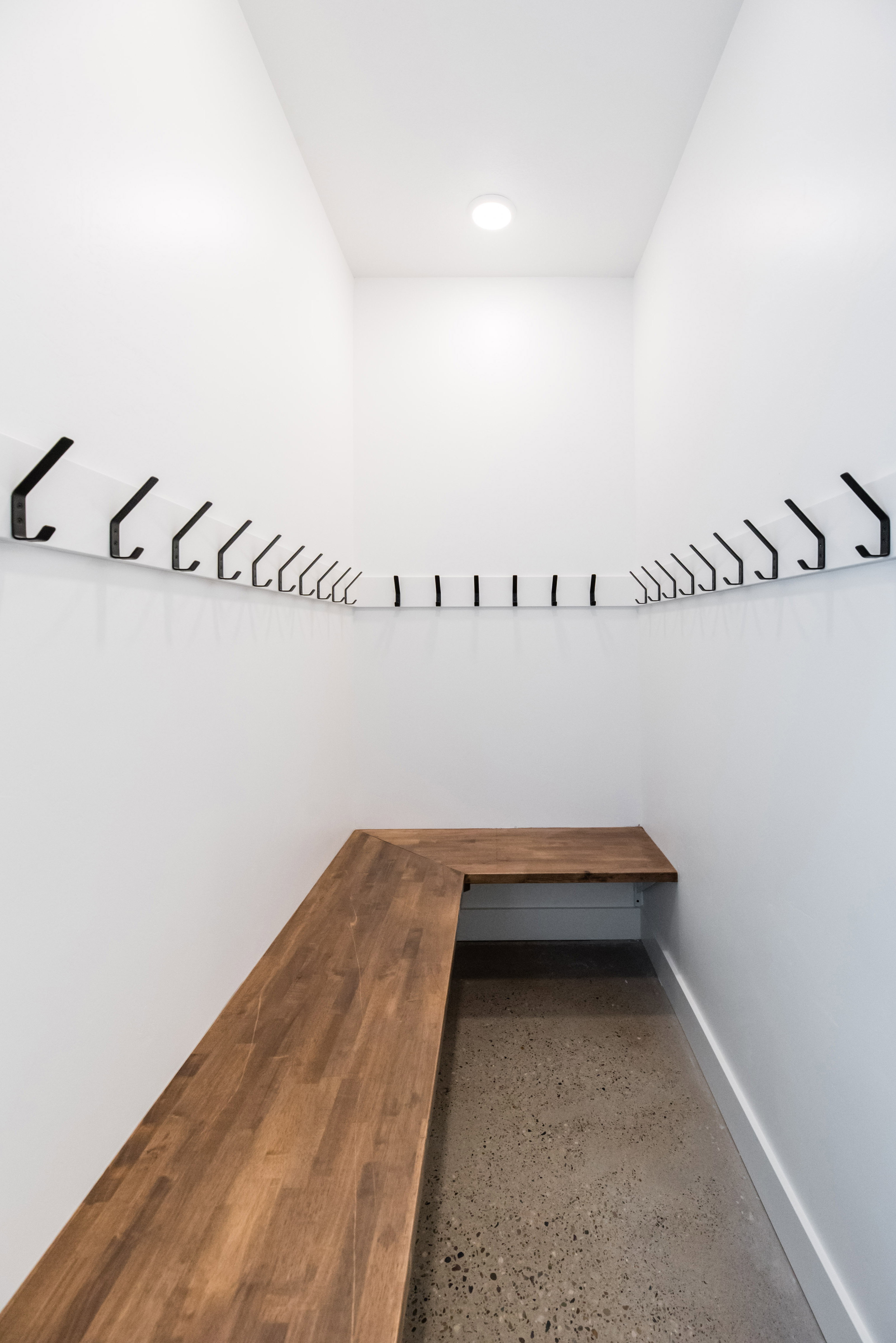 Entryway featuring a built-in L-shaped wood bench and concrete flooring