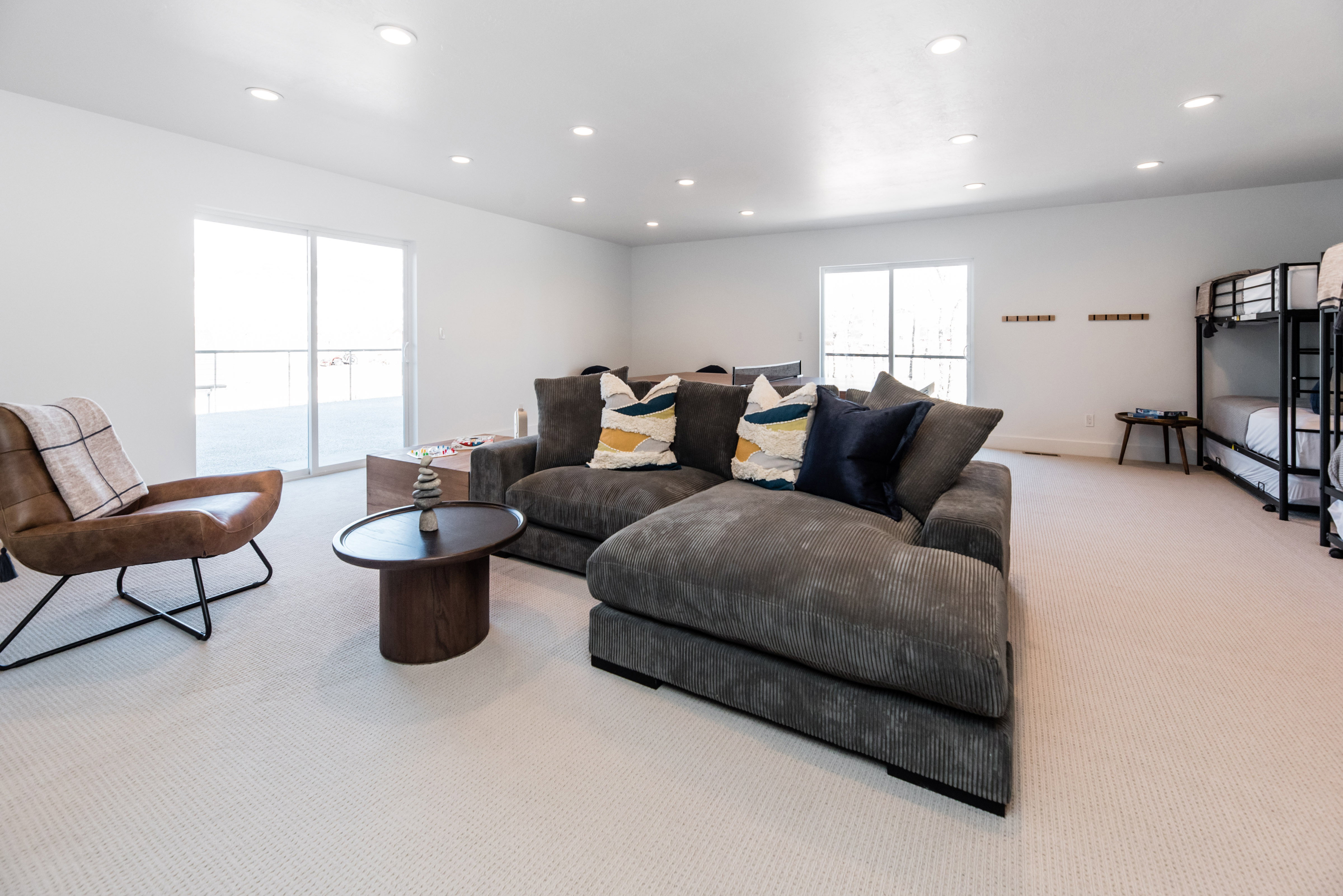 Spacious room featuring light-toned carpet flooring, bright white walls, and recessed lighting