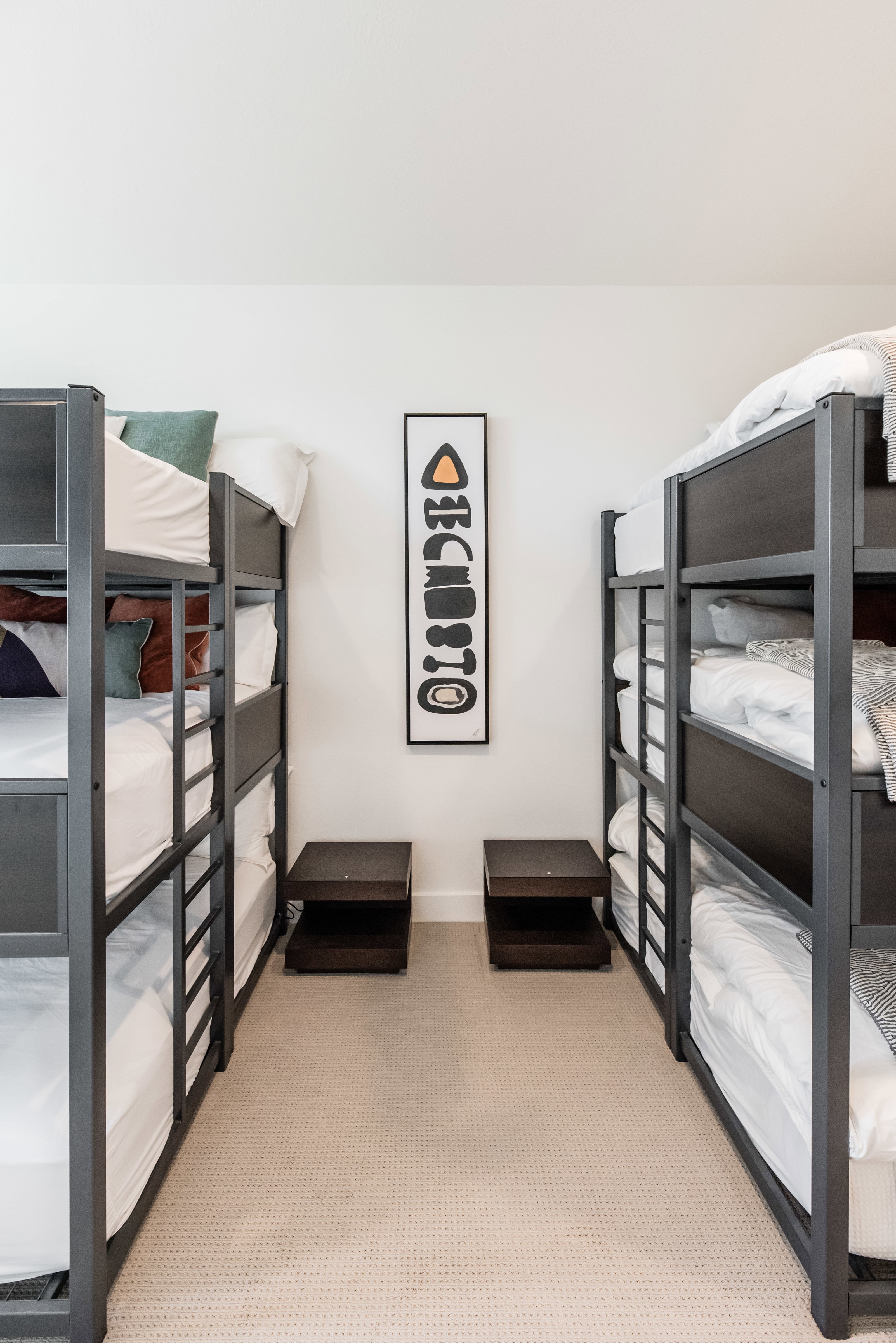 Carpeted room featuring two multi-level bunk beds with dark frames