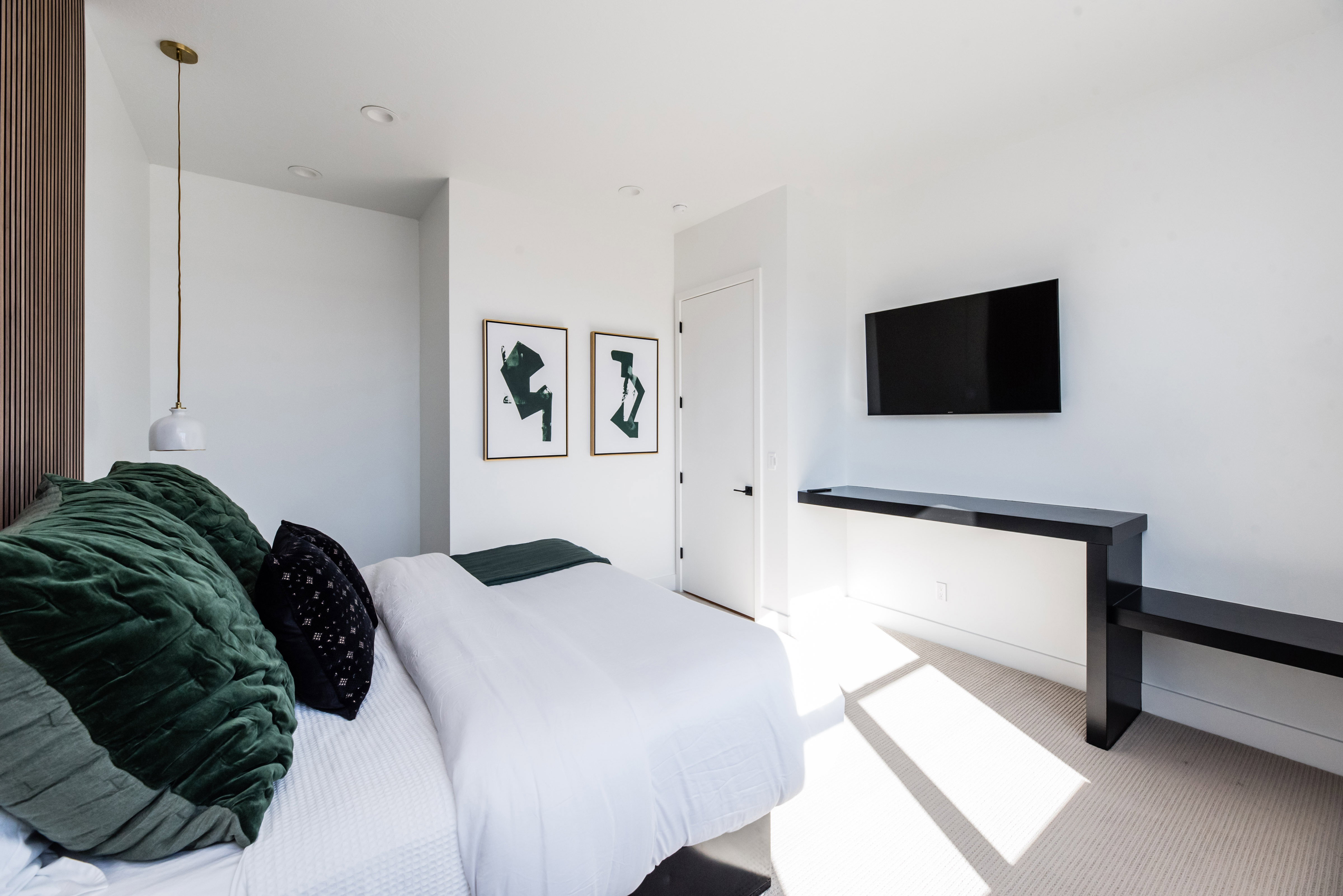 Neutral-toned wall finishes with recessed lighting and a built-in wall-mounted television