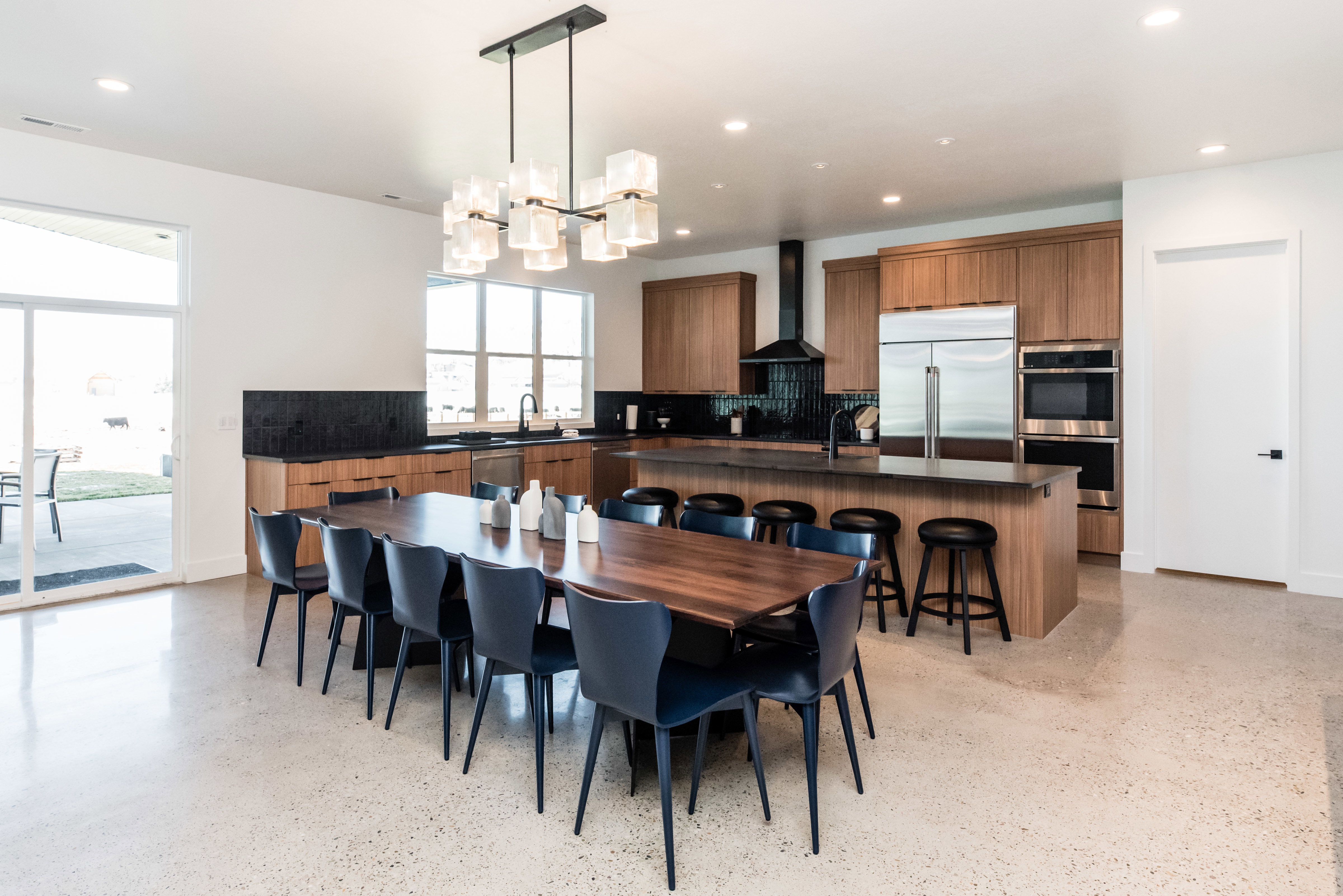 Spacious open-concept kitchen and dining area featuring light wood-finish cabinetry, stainless steel appliances, and a central island with seating