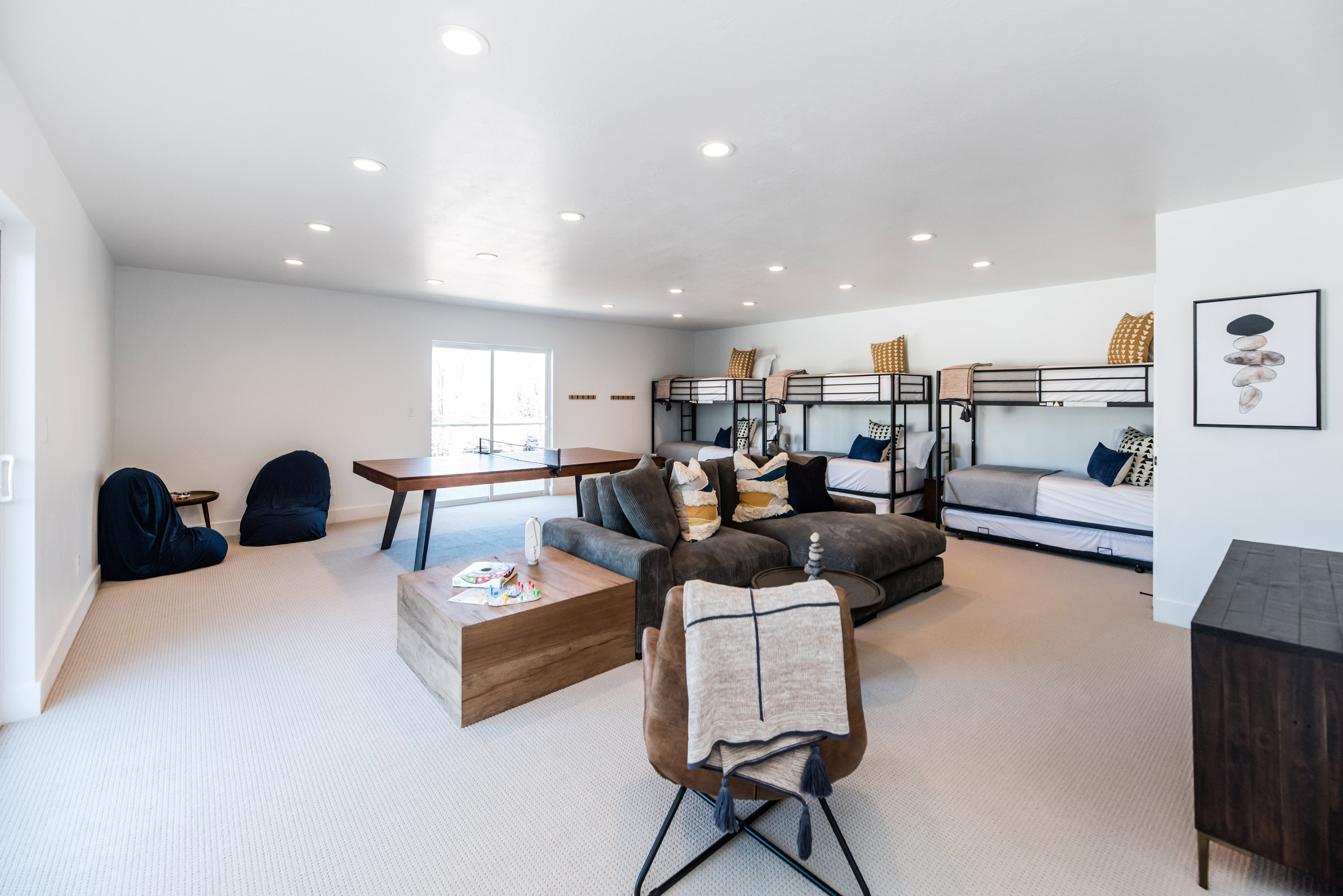 Spacious recreation room featuring recessed lighting, light-toned carpet, a large window, and multiple built-in bunk beds