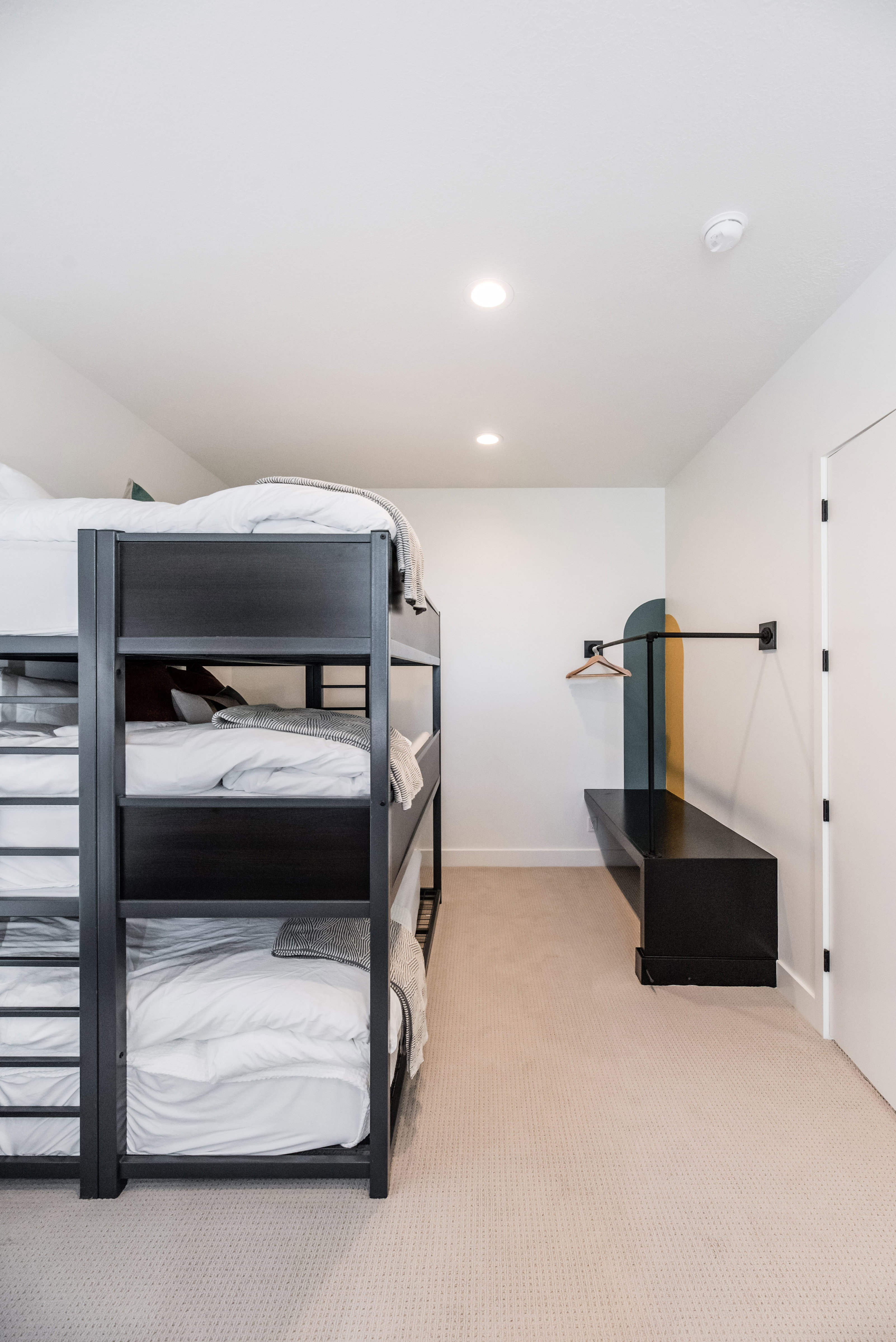 Room featuring a built-in triple bunk bed with a ladder, recessed lighting, and light-toned carpet flooring
