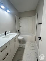 Modern bathroom featuring a white vanity with integrated sink, matte black faucet, and bronze hardware